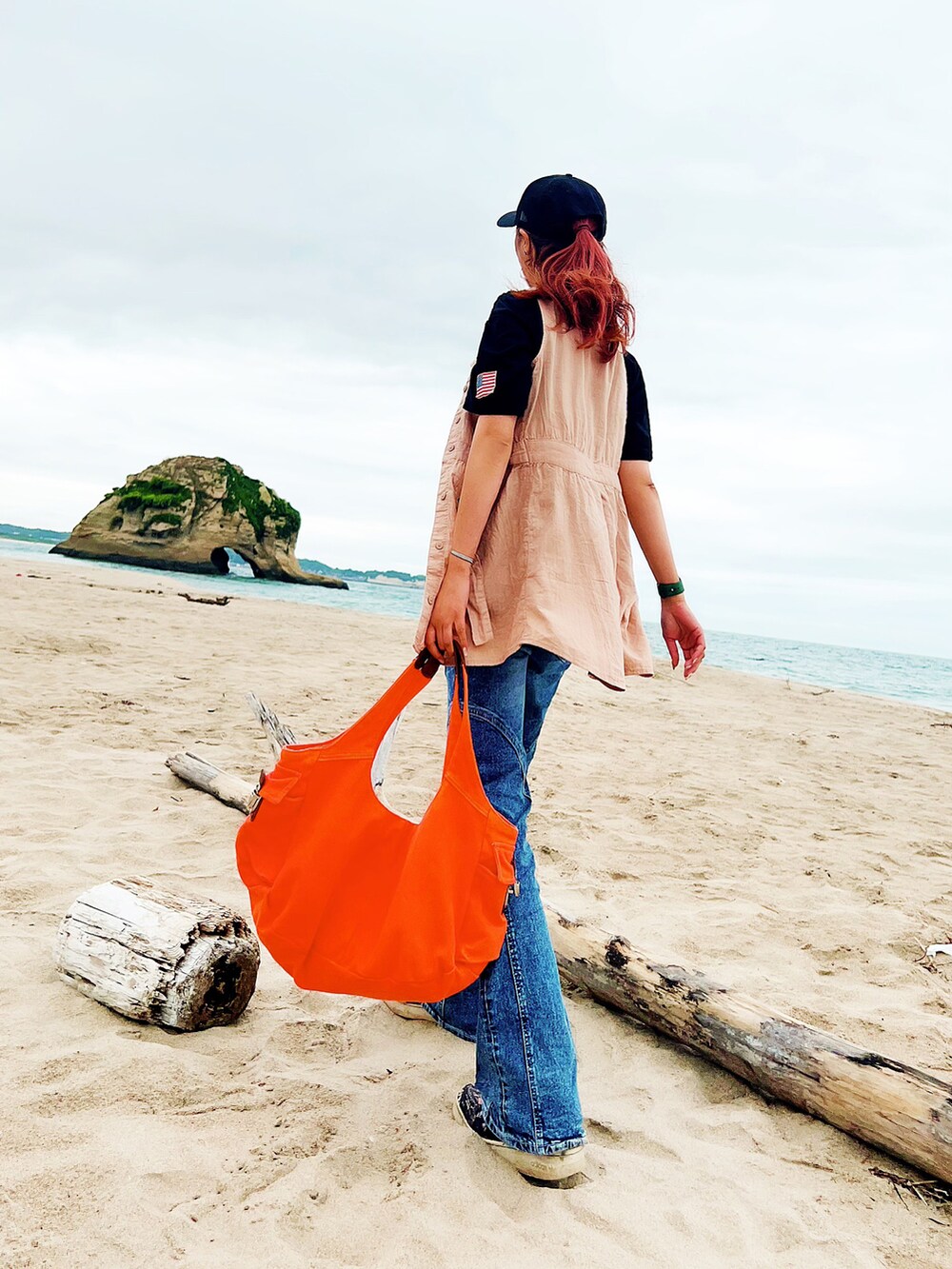 ブラック系のTシャツ/カットソー、ベージュ系のワンピース、ブルー系のデニムパンツを着用したレディースの夏コーディネートの2枚目の写真