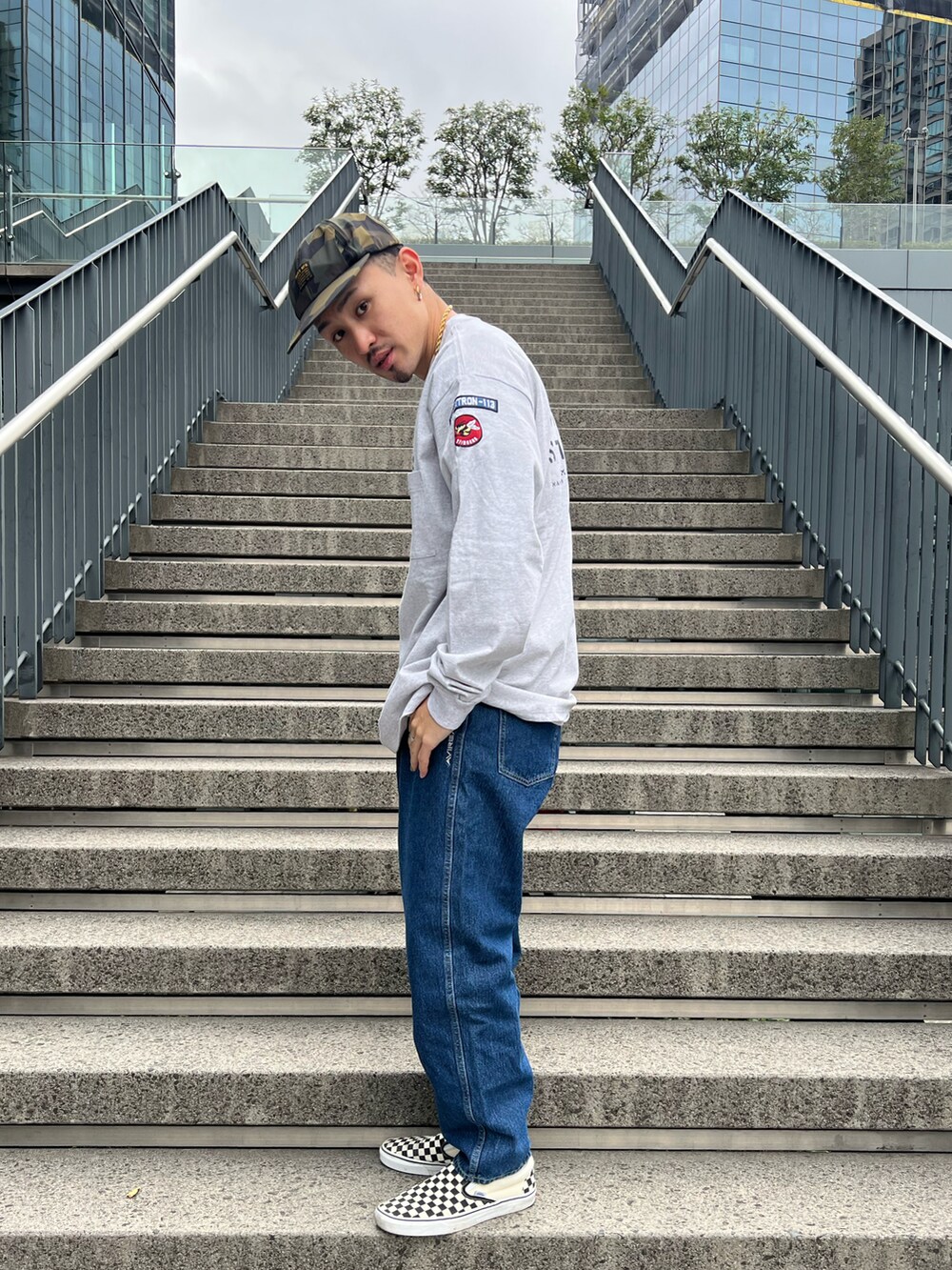 グレー系のTシャツ/カットソー、その他のデニムパンツ、ブラック系のキャップを着用したメンズの冬コーディネートの2枚目の写真