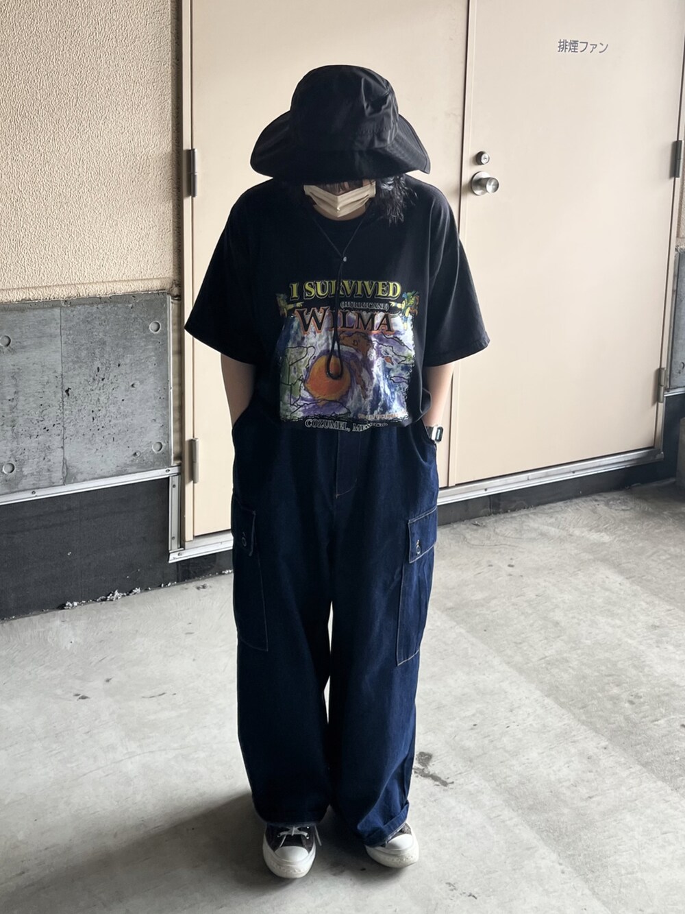 ブルー系のデニムパンツ、ブラック系のスニーカー、ブラック系のTシャツ/カットソーを着用したレディースの夏コーディネートの2枚目の写真