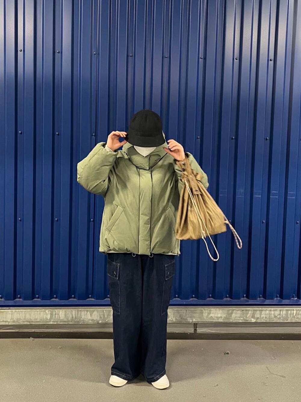 グリーン系のダウンジャケット/コート、ブルー系のデニムパンツを着用したレディースの冬コーディネートの2枚目の写真