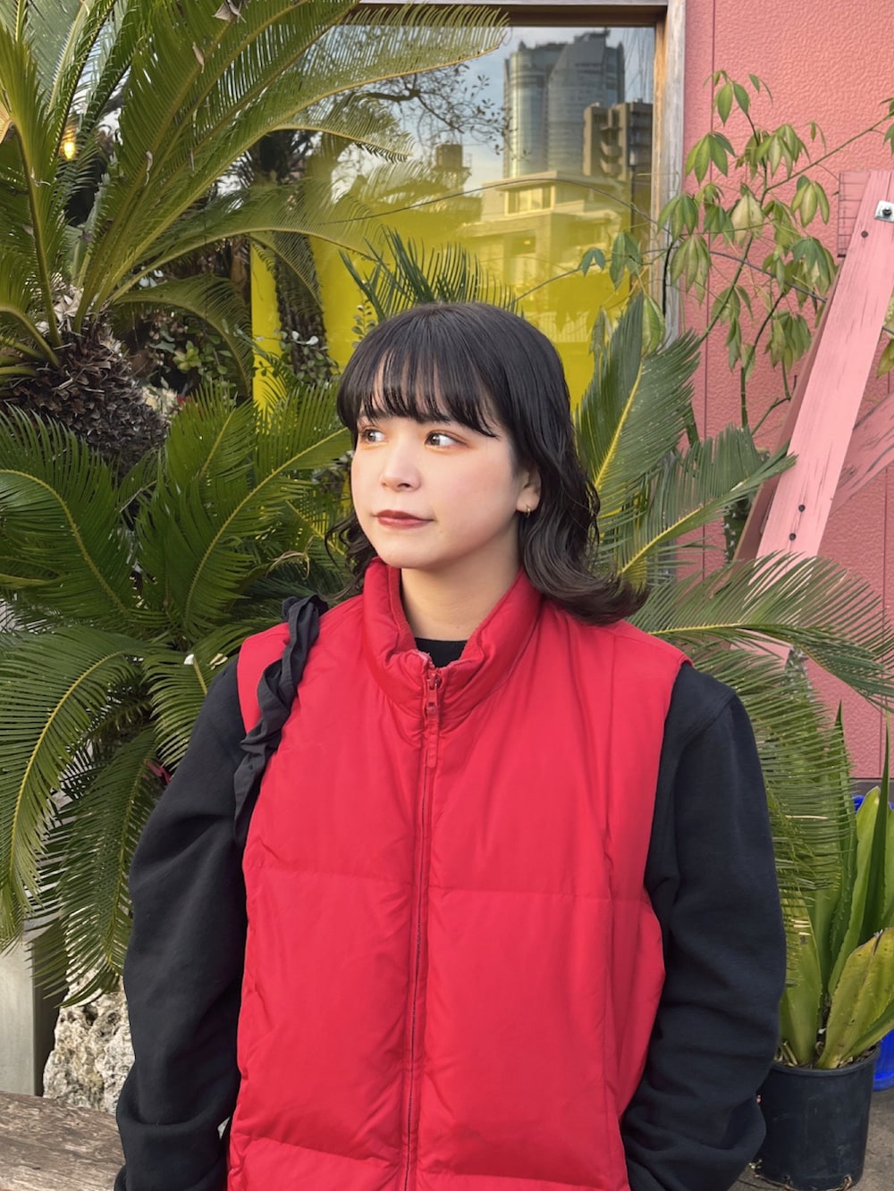 レッド系のナイロンジャケット、ブラック系のモカシン/デッキシューズを着用したレディースの冬コーディネートの3枚目の写真