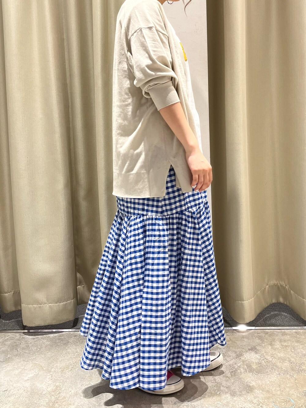 ブルー系のスカート、ホワイト系のTシャツ/カットソー、グレー系のカーディガン/ボレロを着用したレディースの春コーディネートの2枚目の写真