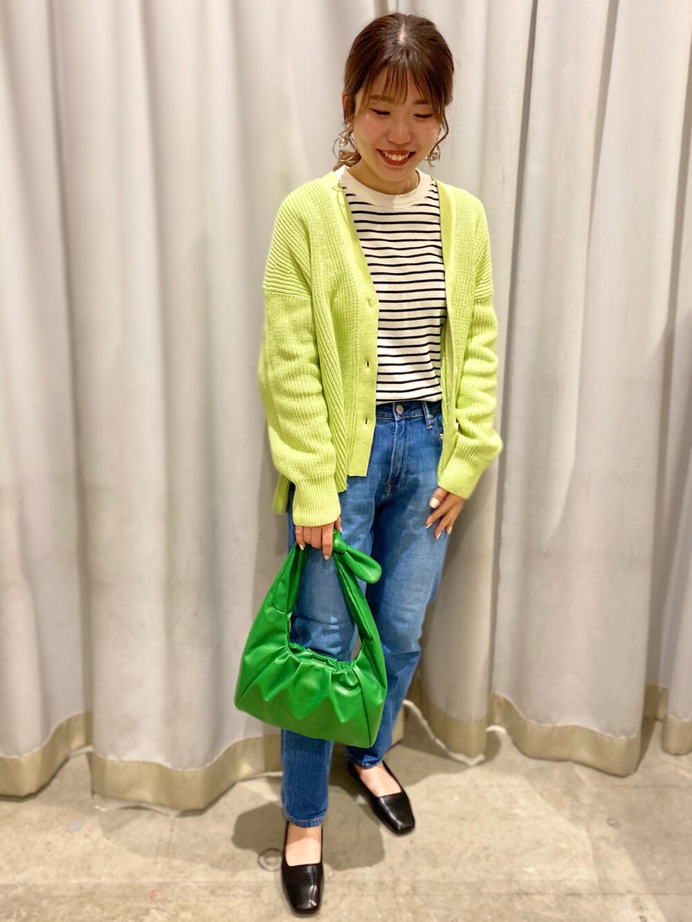 グリーン系のカーディガン/ボレロ、その他のTシャツ/カットソー、ブルー系のデニムパンツを着用したレディースの冬コーディネートの2枚目の写真