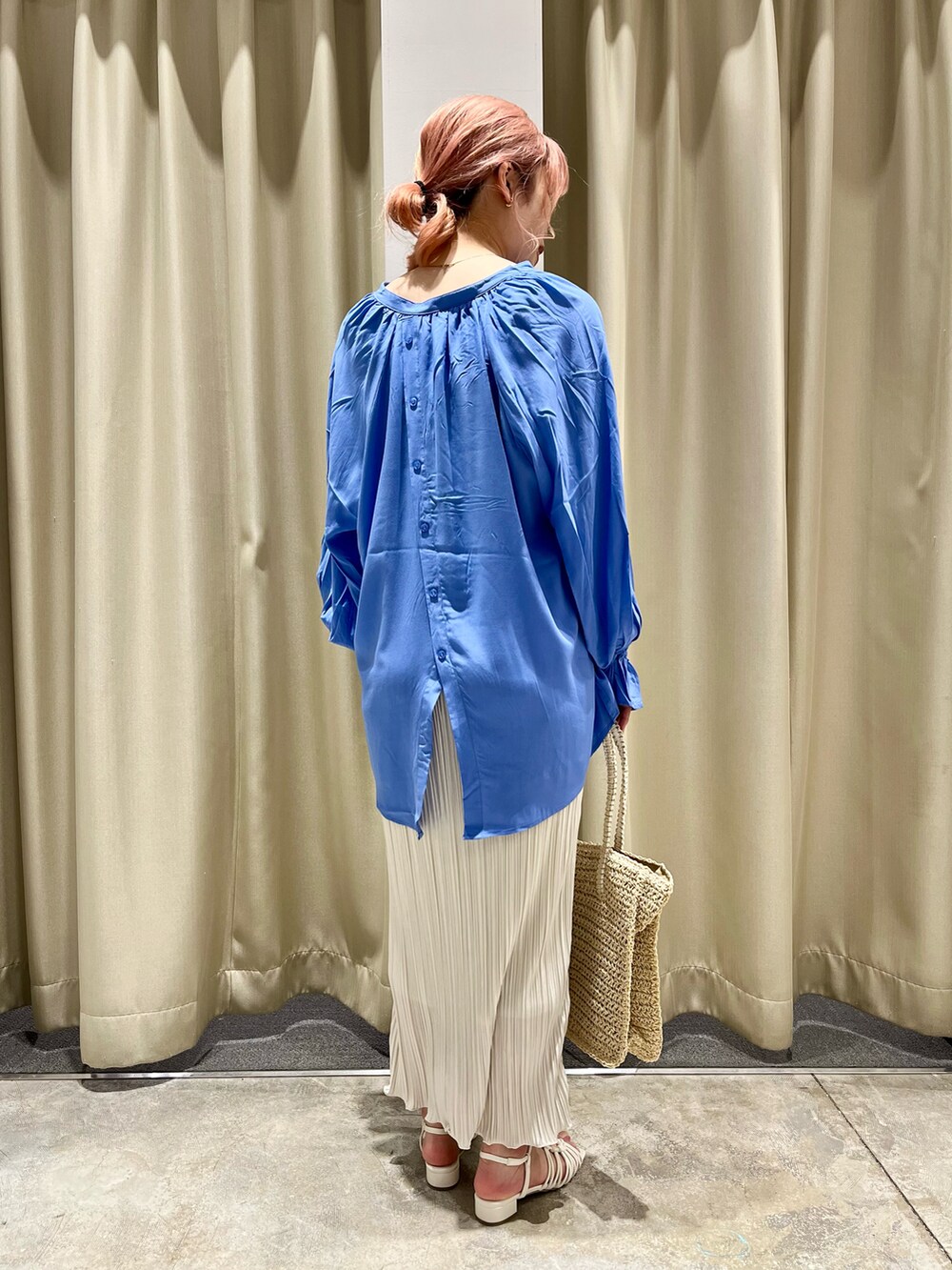 ベージュ系のスカート、ベージュ系のかごバッグ、ホワイト系のサンダルを着用したレディースの春コーディネートの2枚目の写真