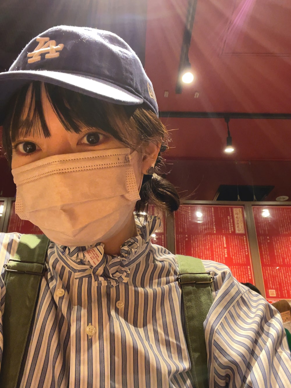 ブルー系のシャツ/ブラウス、グリーン系のサロペット/オーバーオール、ブルー系のバッグを着用したレディースの秋コーディネートの2枚目の写真