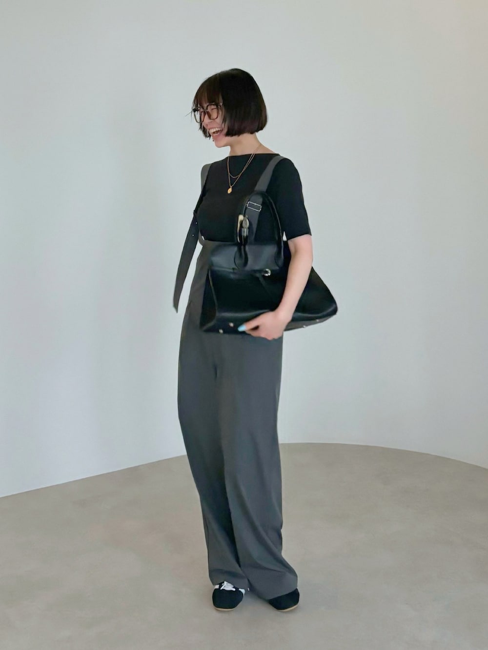 ブラウン系のハンドバッグ、ブラック系のTシャツ/カットソー、グレー系のサロペット/オーバーオールを着用したレディースの夏コーディネートの2枚目の写真