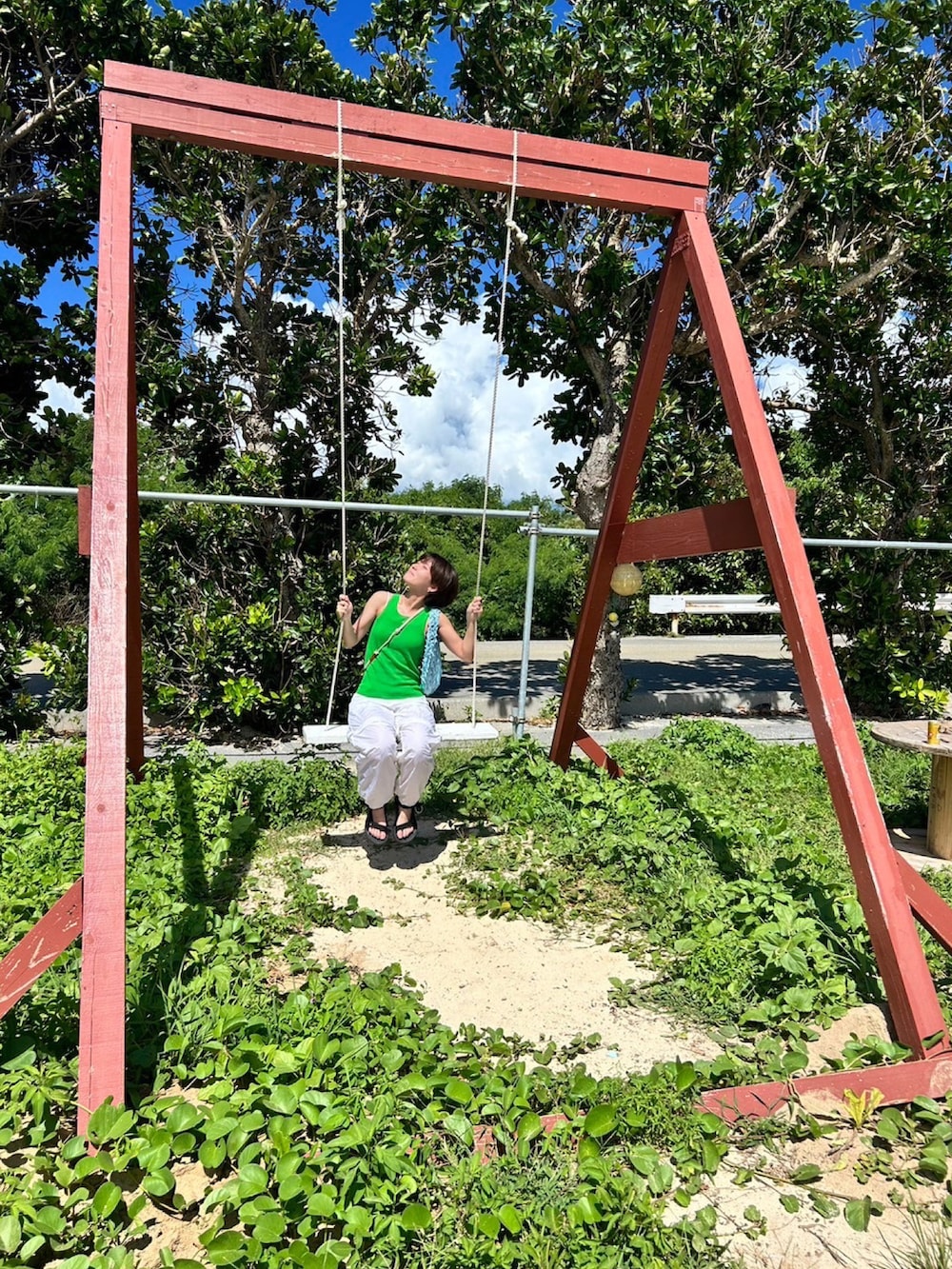 グリーン系のタンクトップ、ホワイト系のその他パンツ、ブラック系のサンダルを着用したレディースの夏コーディネートの2枚目の写真