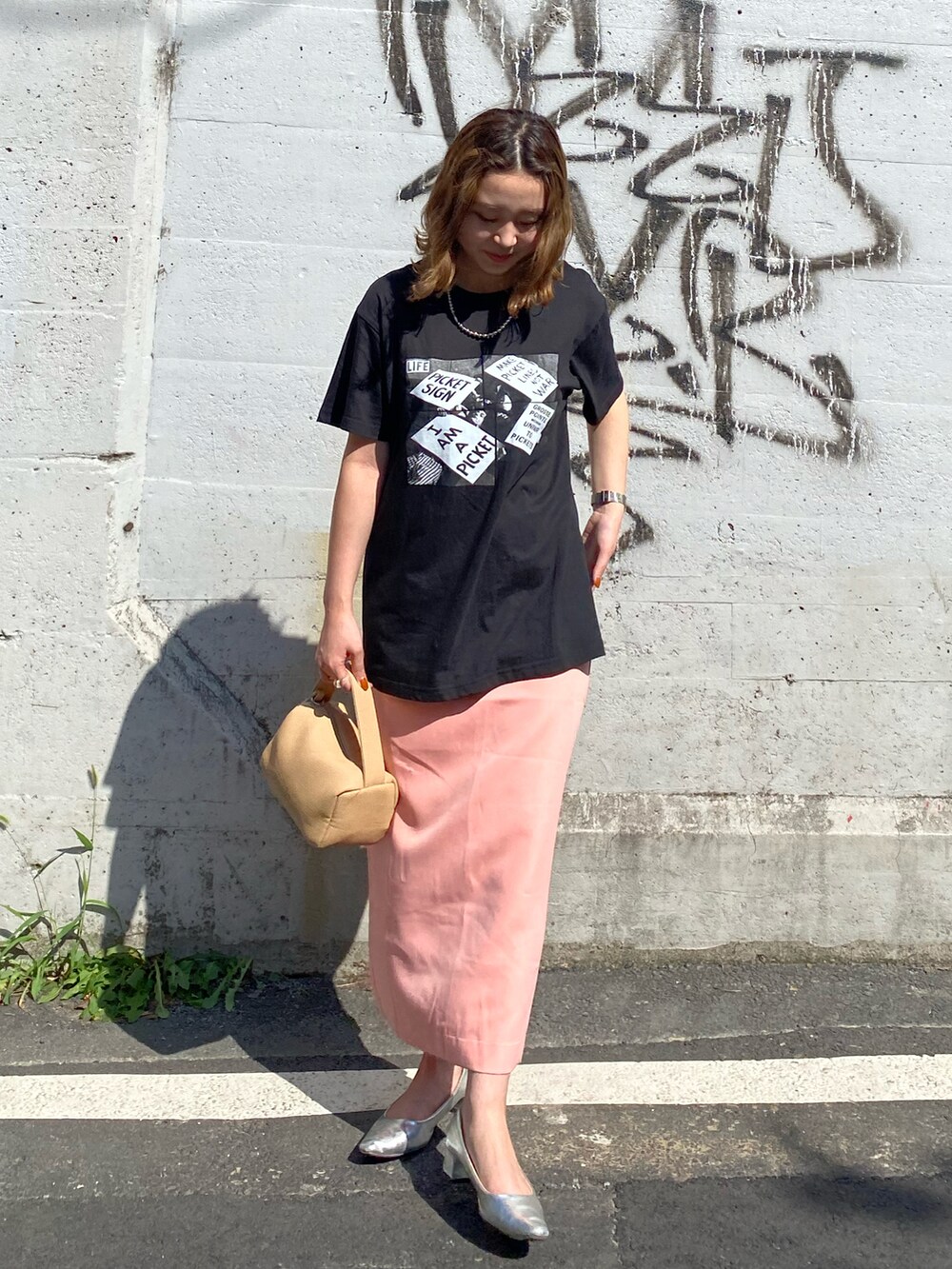 ブラック系のTシャツ/カットソー、ピンク系のスカート、シルバー系のネックレスを着用したレディースの夏コーディネートの2枚目の写真