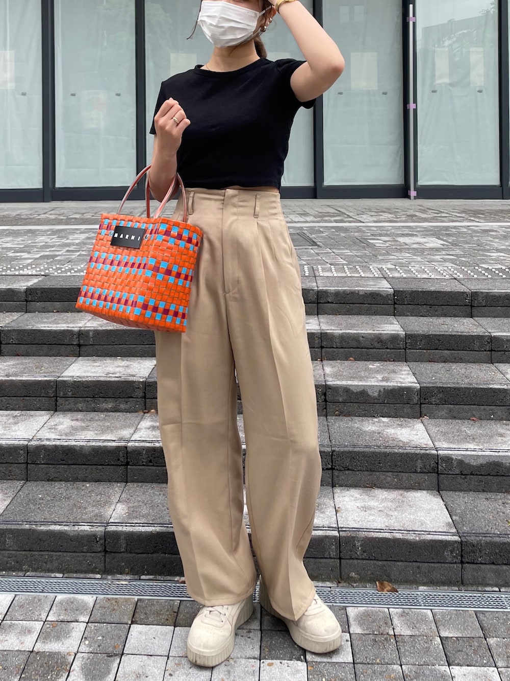 ブラック系のTシャツ/カットソー、オレンジ系のかごバッグを着用したレディースの春コーディネートの2枚目の写真