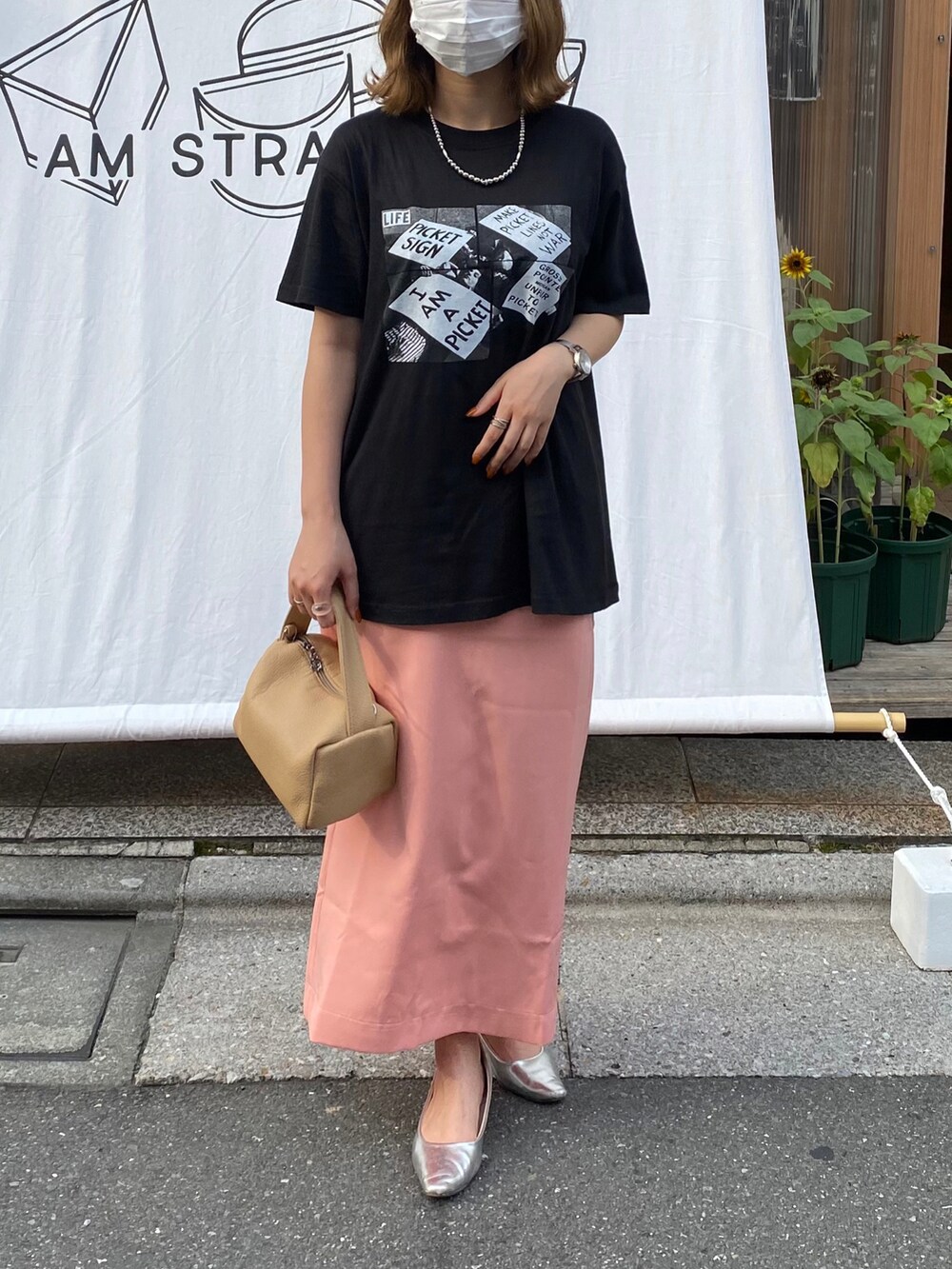 ブラック系のTシャツ/カットソー、ピンク系のスカート、シルバー系のネックレスを着用したレディースの夏コーディネートの3枚目の写真
