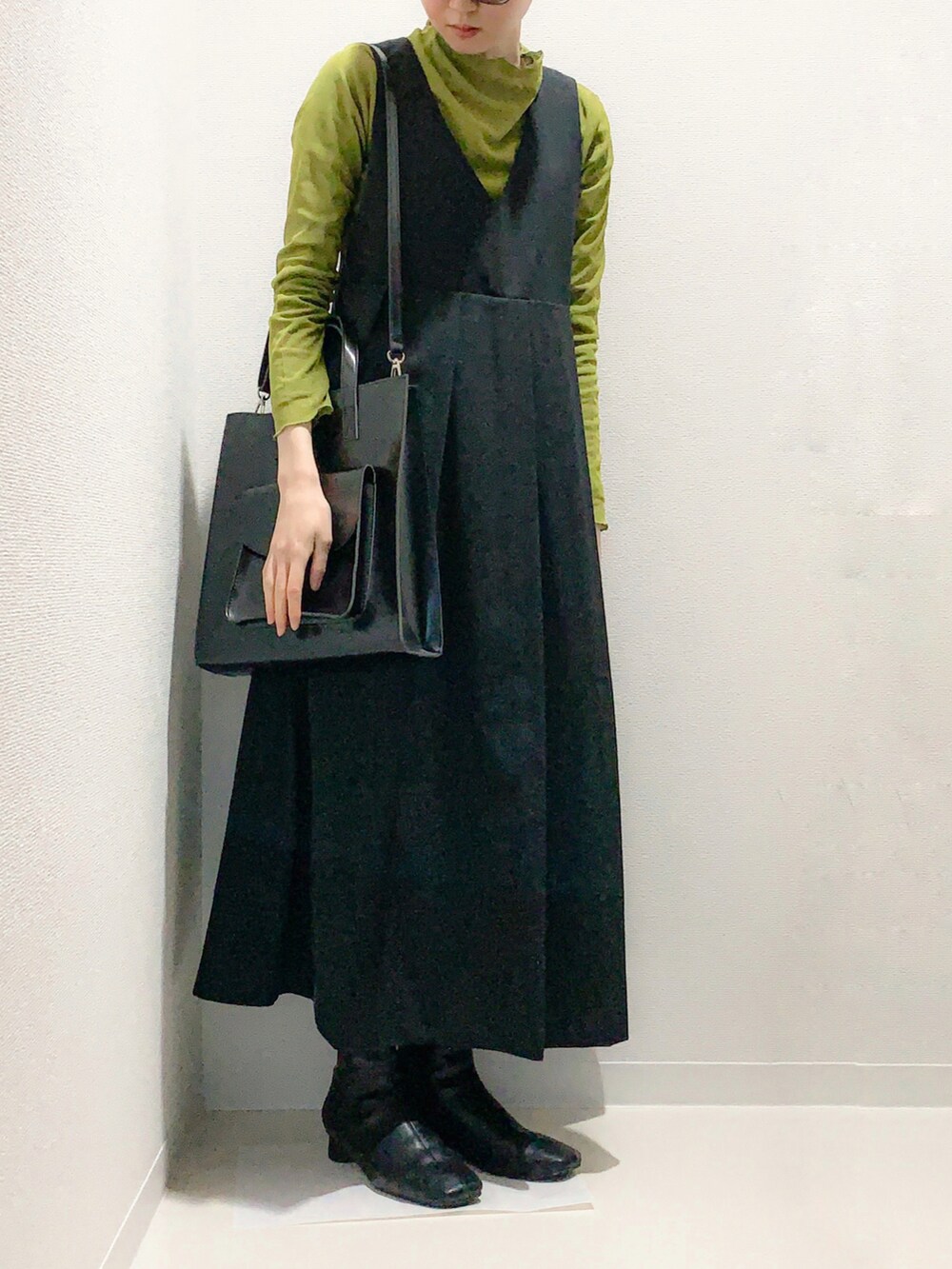 ブラック系のワンピースを着用したレディースの冬コーディネートの2枚目の写真