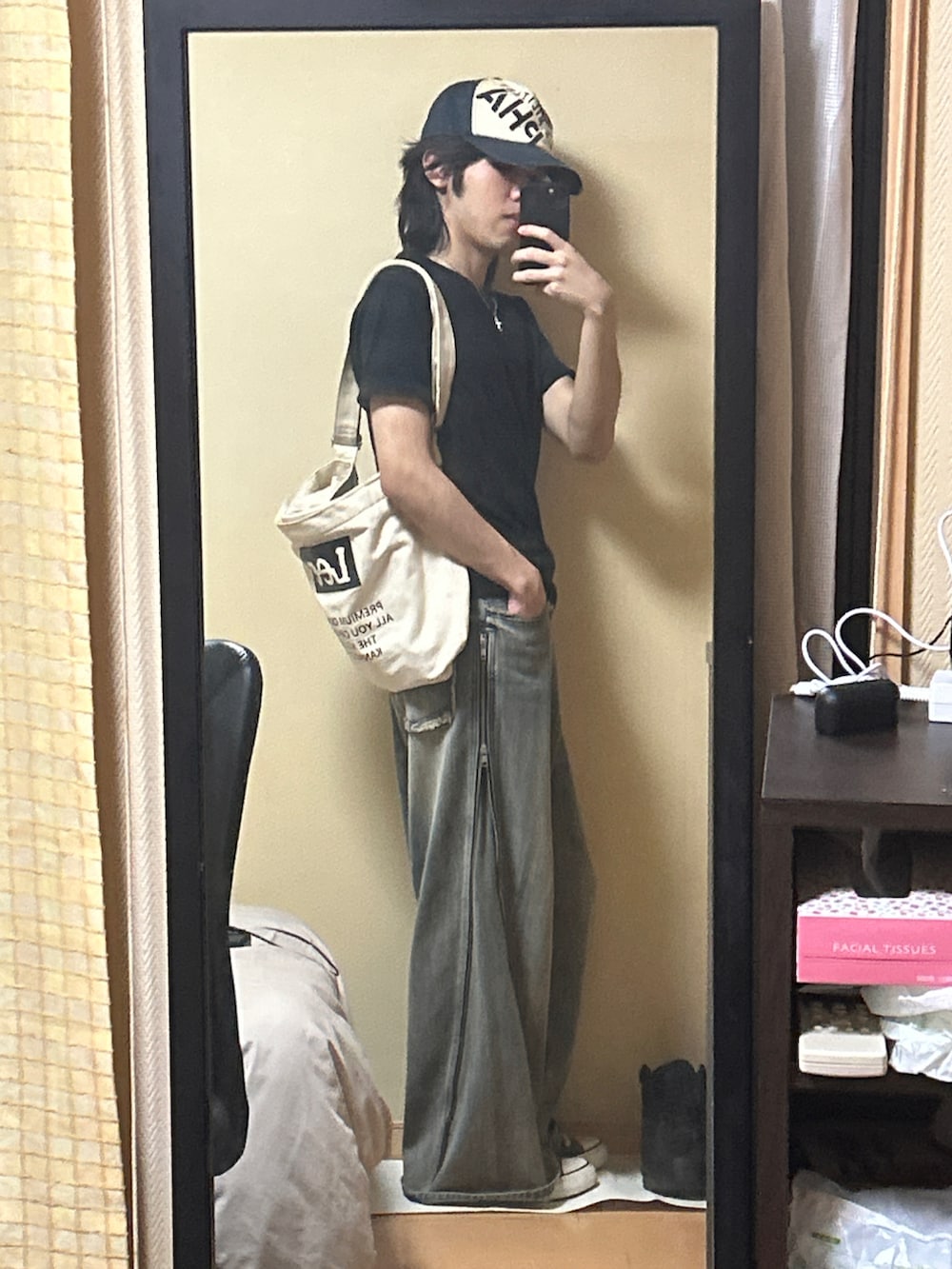 ブラック系のスニーカー、ブルー系のデニムパンツ、ブラック系のTシャツ/カットソーを着用したメンズの秋コーディネートの2枚目の写真