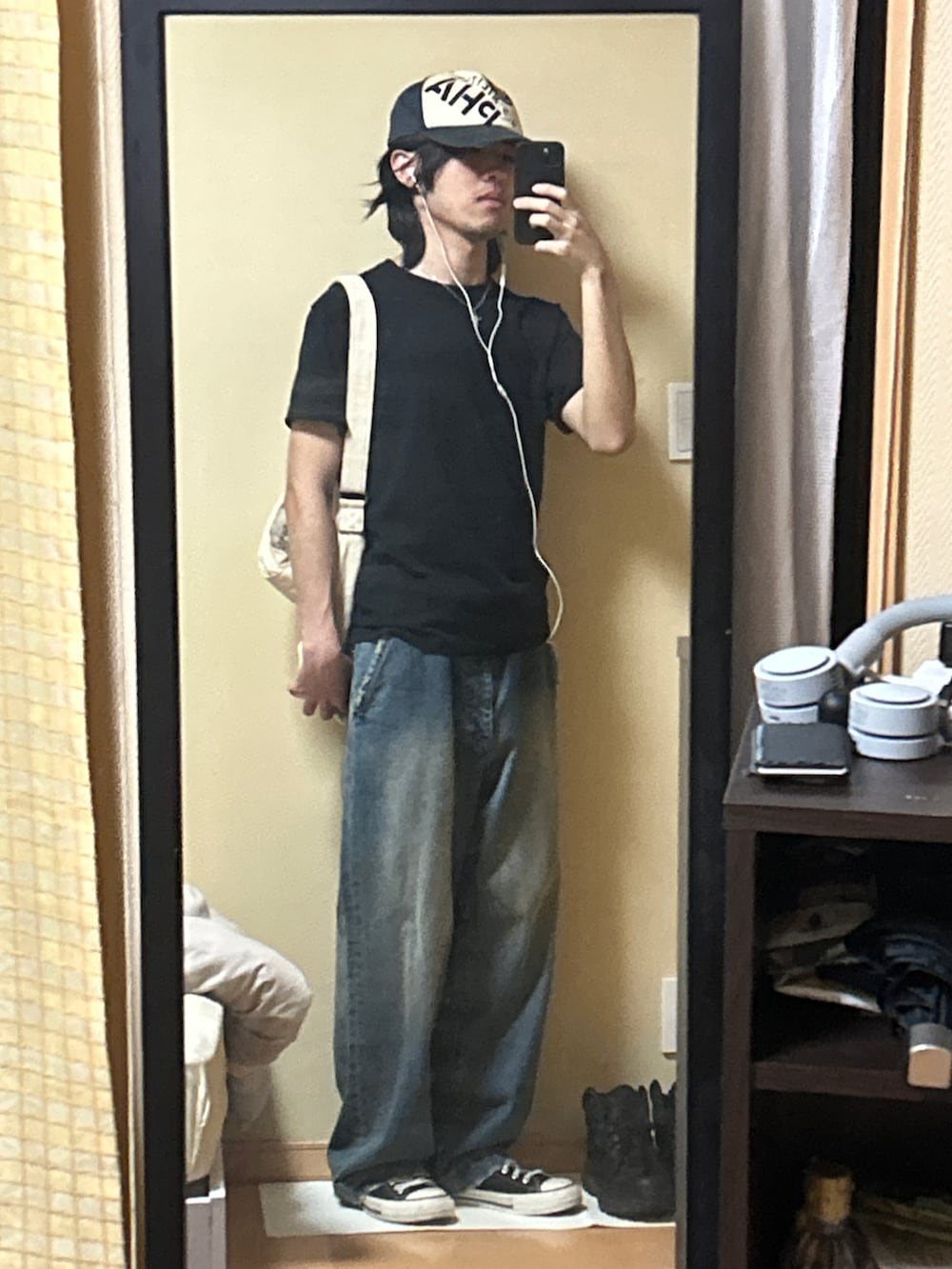 ブラック系のスニーカー、ブルー系のデニムパンツ、ブラック系のTシャツ/カットソーを着用したメンズの秋コーディネートの5枚目の写真