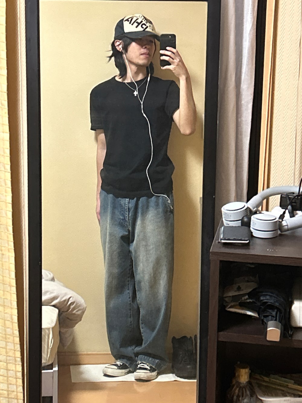 ブラック系のスニーカー、ブルー系のデニムパンツ、ブラック系のTシャツ/カットソーを着用したメンズの秋コーディネートの3枚目の写真