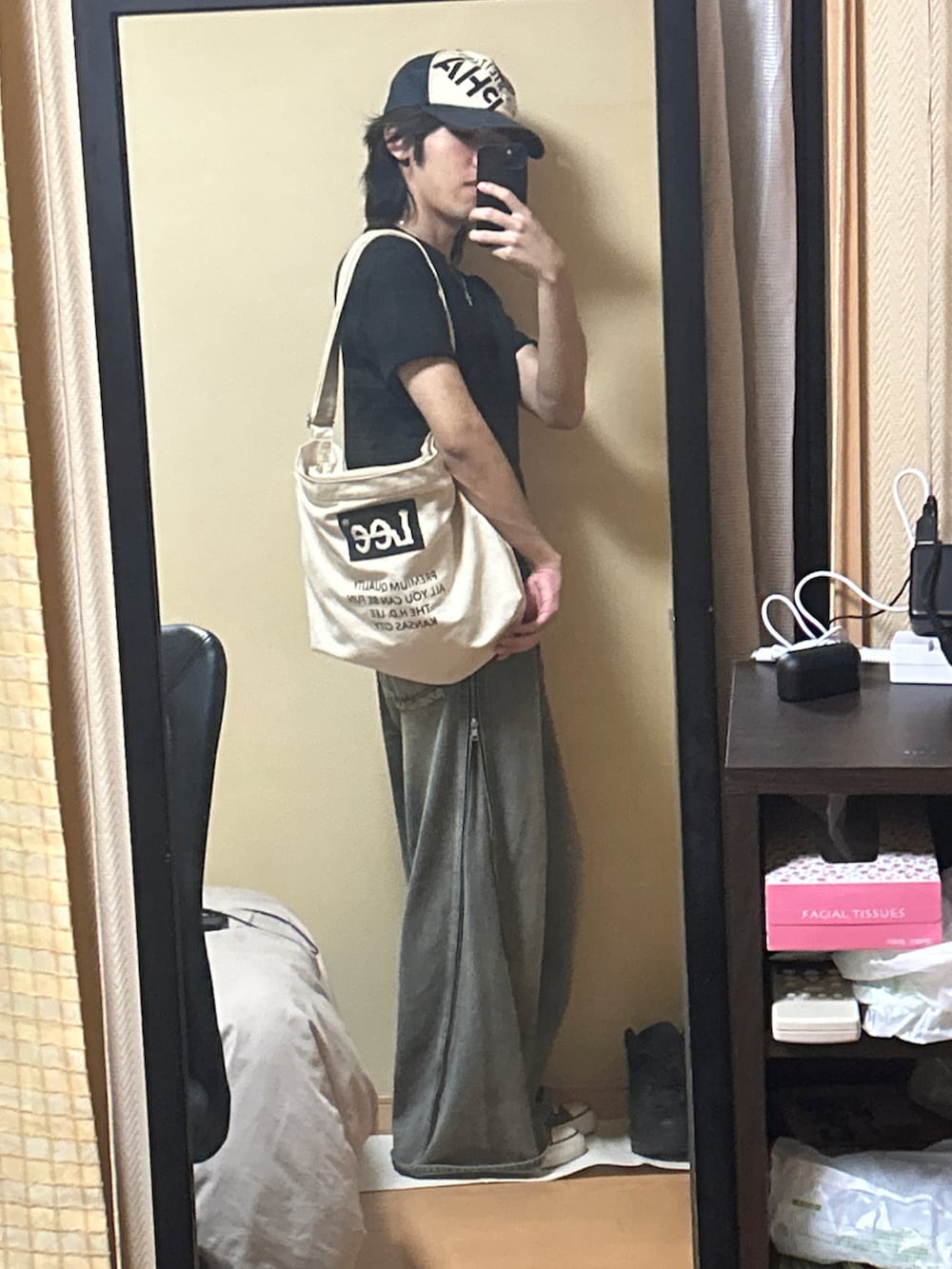 ブラック系のスニーカー、ブルー系のデニムパンツ、ブラック系のTシャツ/カットソーを着用したメンズの秋コーディネートの3枚目の写真