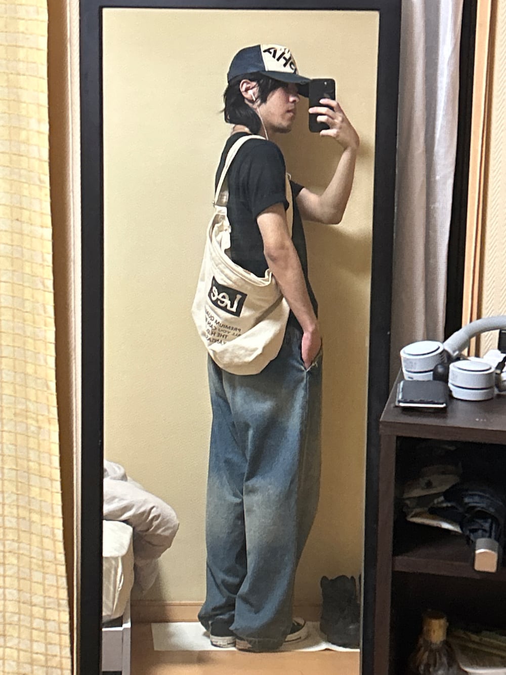 ブラック系のスニーカー、ブルー系のデニムパンツ、ブラック系のTシャツ/カットソーを着用したメンズの秋コーディネートの4枚目の写真