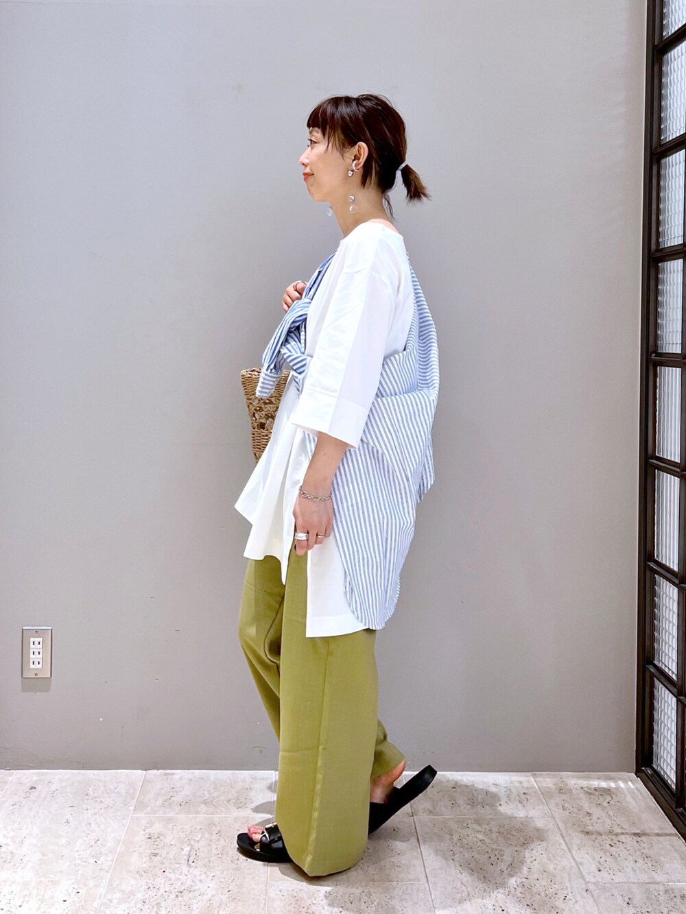 ベージュ系のトートバッグ、ホワイト系のTシャツ/カットソー、ブルー系のシャツ/ブラウスを着用したレディースの春コーディネートの2枚目の写真