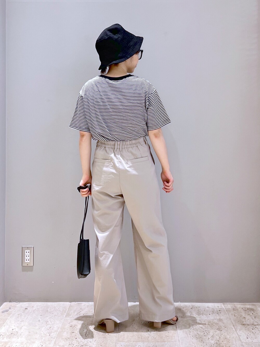 ベージュ系のサンダル、ブラック系のショルダーバッグ、ブラック系のTシャツ/カットソーを着用したレディースの夏コーディネートの3枚目の写真