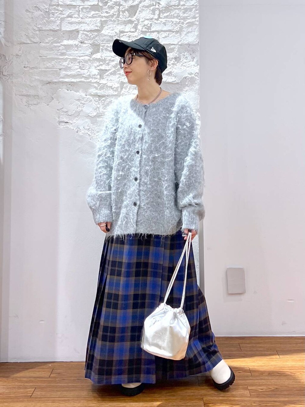 ホワイト系のブーツ、ブルー系のスカート、グレー系のカーディガン/ボレロを着用したレディースの冬コーディネートの5枚目の写真