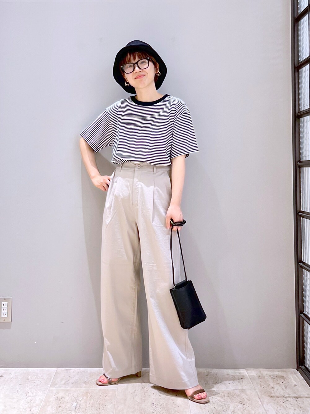 ベージュ系のサンダル、ブラック系のショルダーバッグ、ブラック系のTシャツ/カットソーを着用したレディースの夏コーディネートの2枚目の写真