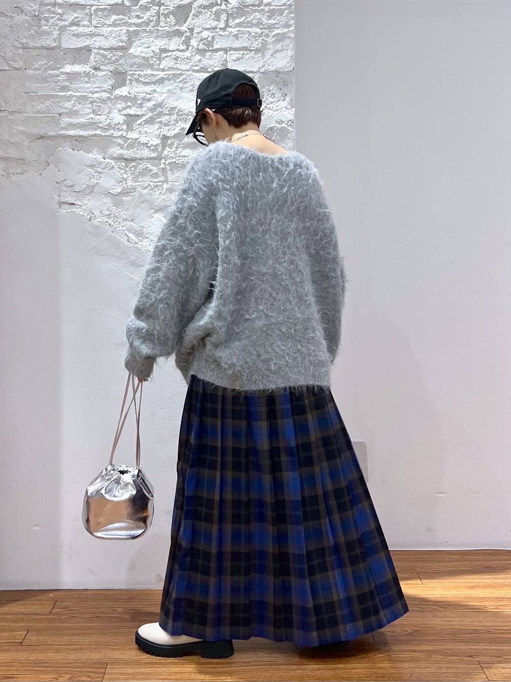 ホワイト系のブーツ、ブルー系のスカート、グレー系のカーディガン/ボレロを着用したレディースの冬コーディネートの6枚目の写真