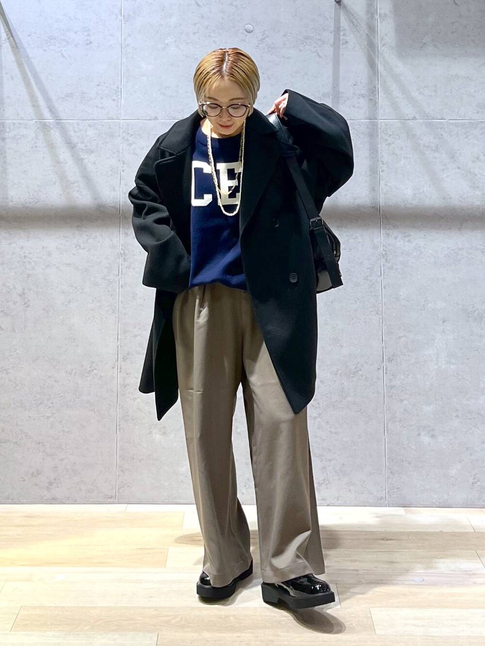 ブラウン系のその他パンツ、ブルー系のニット/セーター、ブラック系のショルダーバッグを着用したレディースの冬コーディネートの5枚目の写真