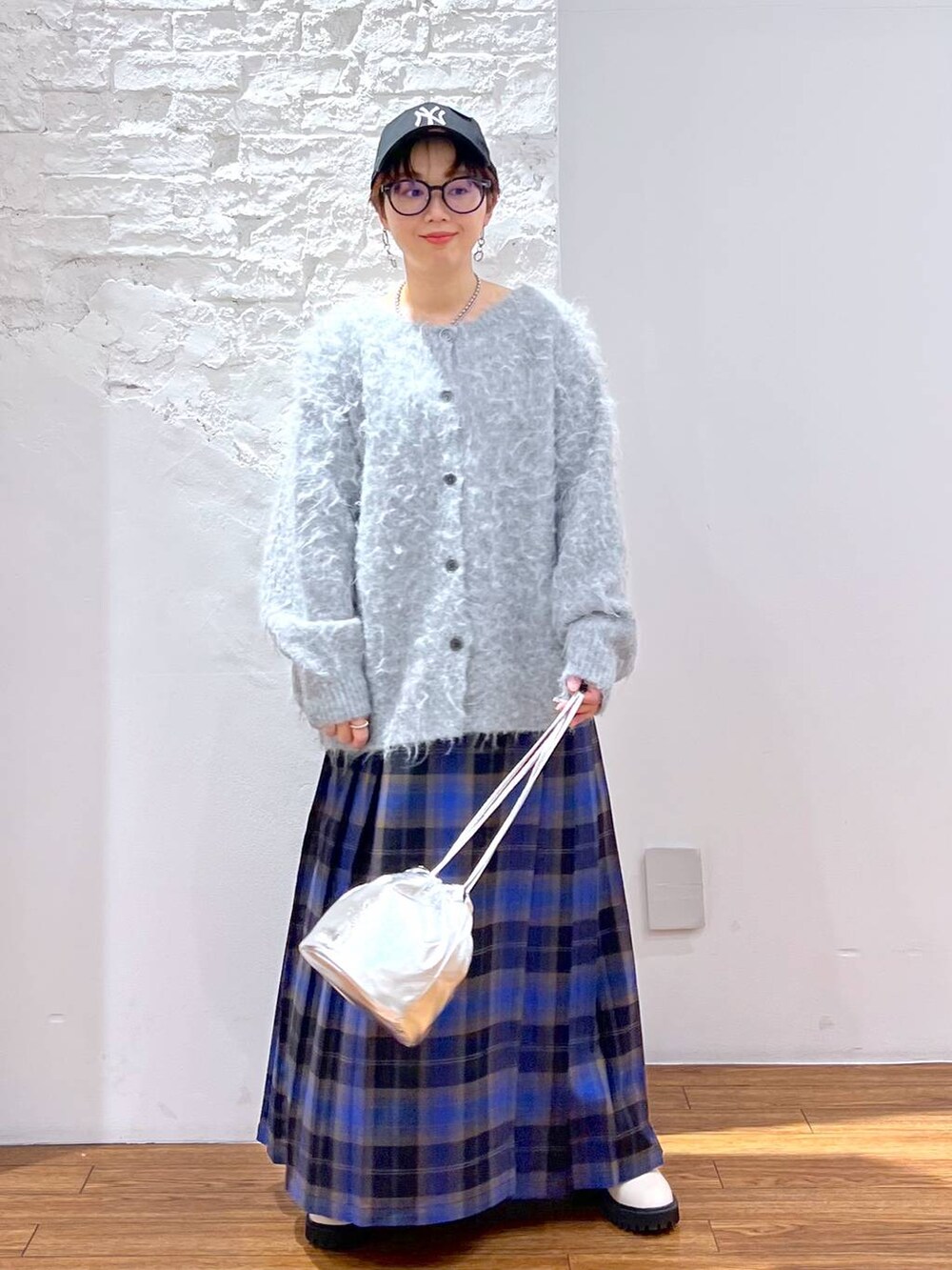 ホワイト系のブーツ、ブルー系のスカート、グレー系のカーディガン/ボレロを着用したレディースの冬コーディネートの4枚目の写真