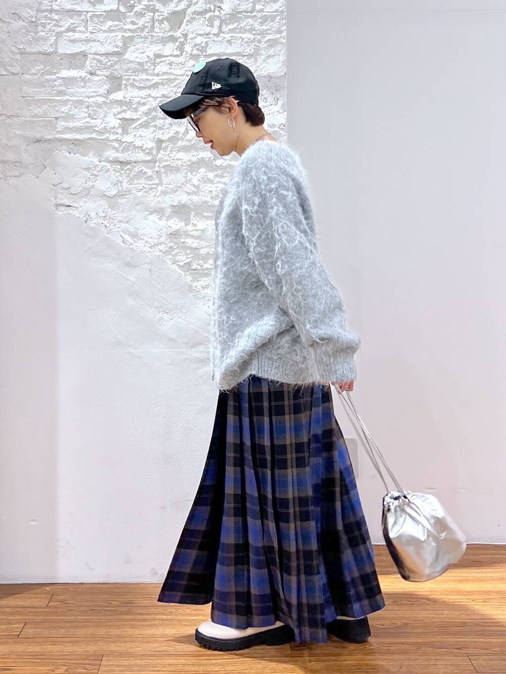 ホワイト系のブーツ、ブルー系のスカート、グレー系のカーディガン/ボレロを着用したレディースの冬コーディネートの2枚目の写真