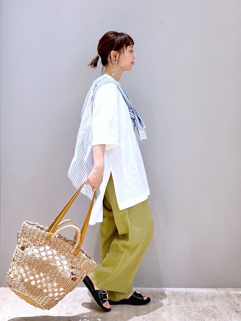 ベージュ系のトートバッグ、ホワイト系のTシャツ/カットソー、ブルー系のシャツ/ブラウスを着用したレディースの春コーディネートの5枚目の写真