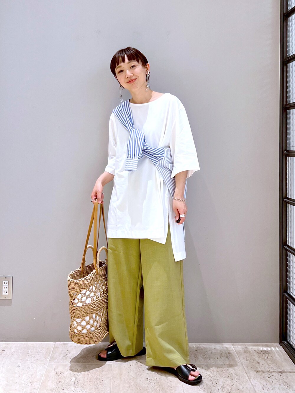 ベージュ系のトートバッグ、ホワイト系のTシャツ/カットソー、ブルー系のシャツ/ブラウスを着用したレディースの春コーディネートの4枚目の写真