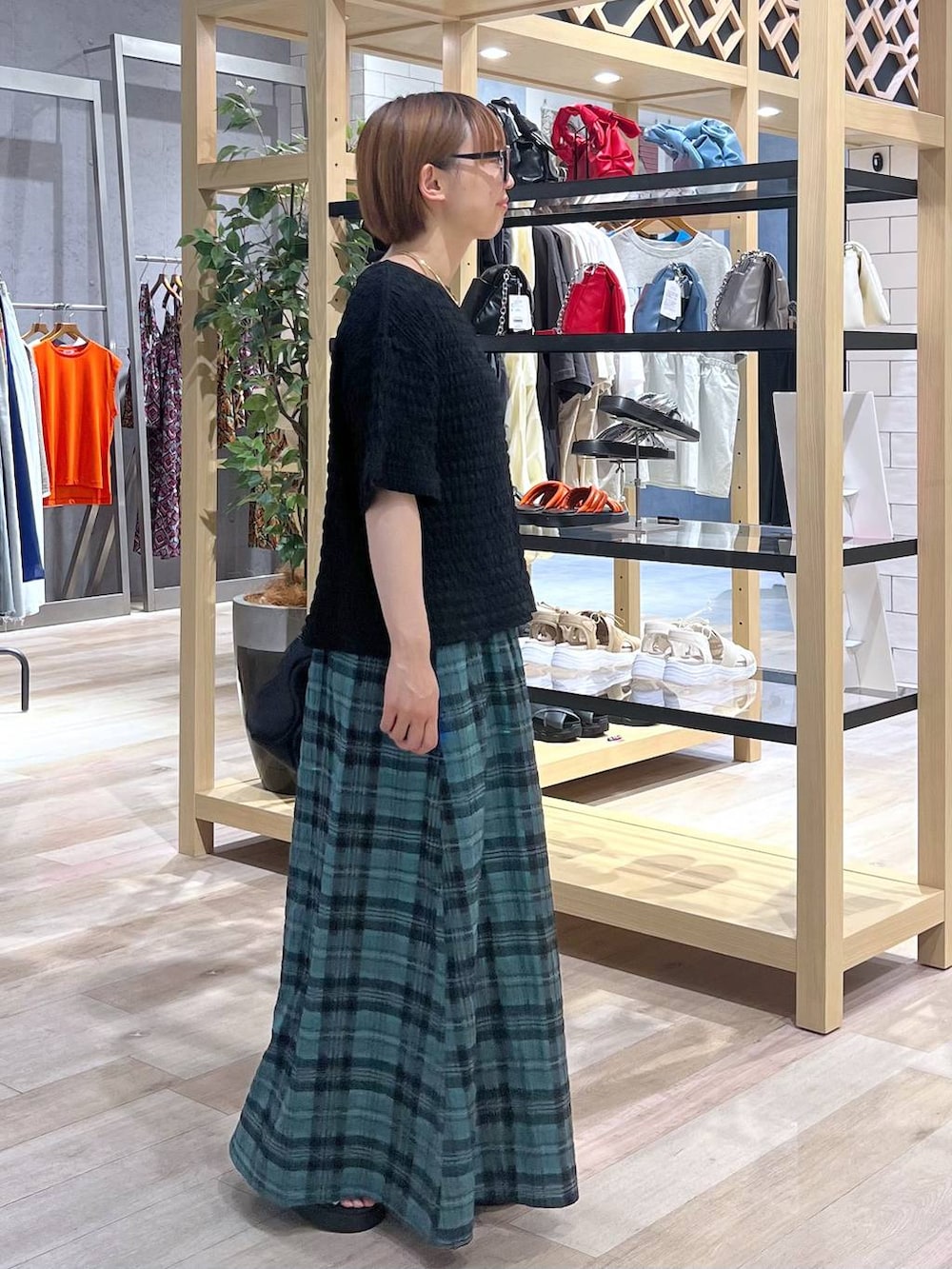 グリーン系のスカート、グレー系のサンダル、ブラック系のTシャツ/カットソーを着用したレディースの夏コーディネートの3枚目の写真