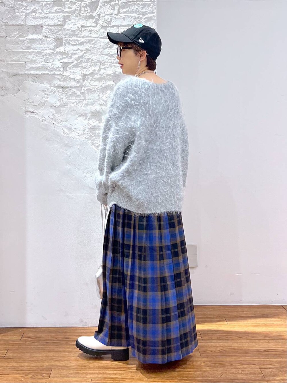 ホワイト系のブーツ、ブルー系のスカート、グレー系のカーディガン/ボレロを着用したレディースの冬コーディネートの3枚目の写真