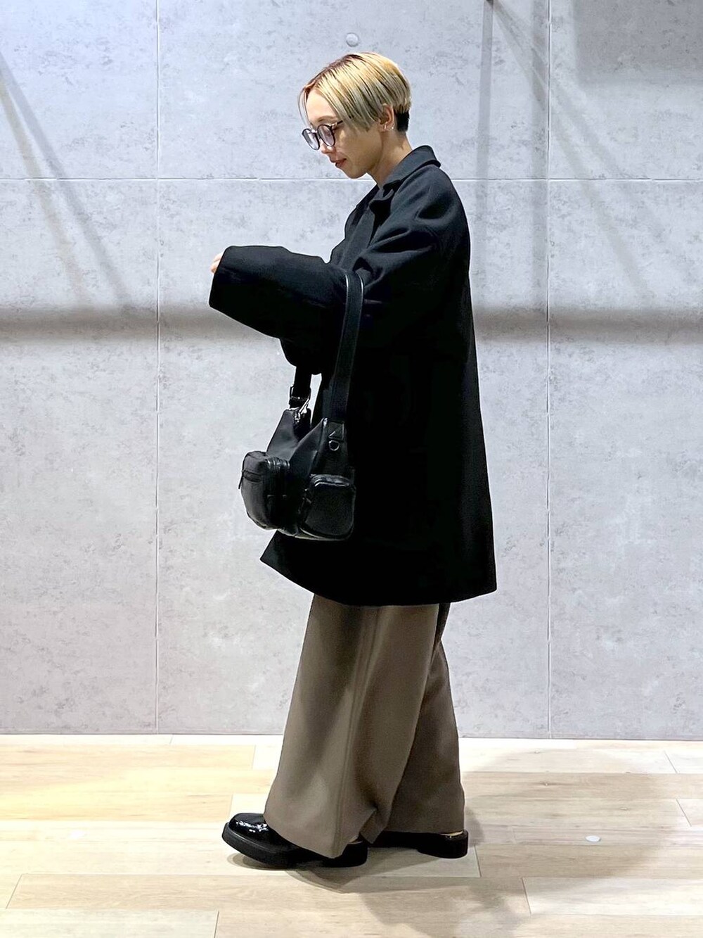 ブラウン系のその他パンツ、ブルー系のニット/セーター、ブラック系のショルダーバッグを着用したレディースの冬コーディネートの3枚目の写真