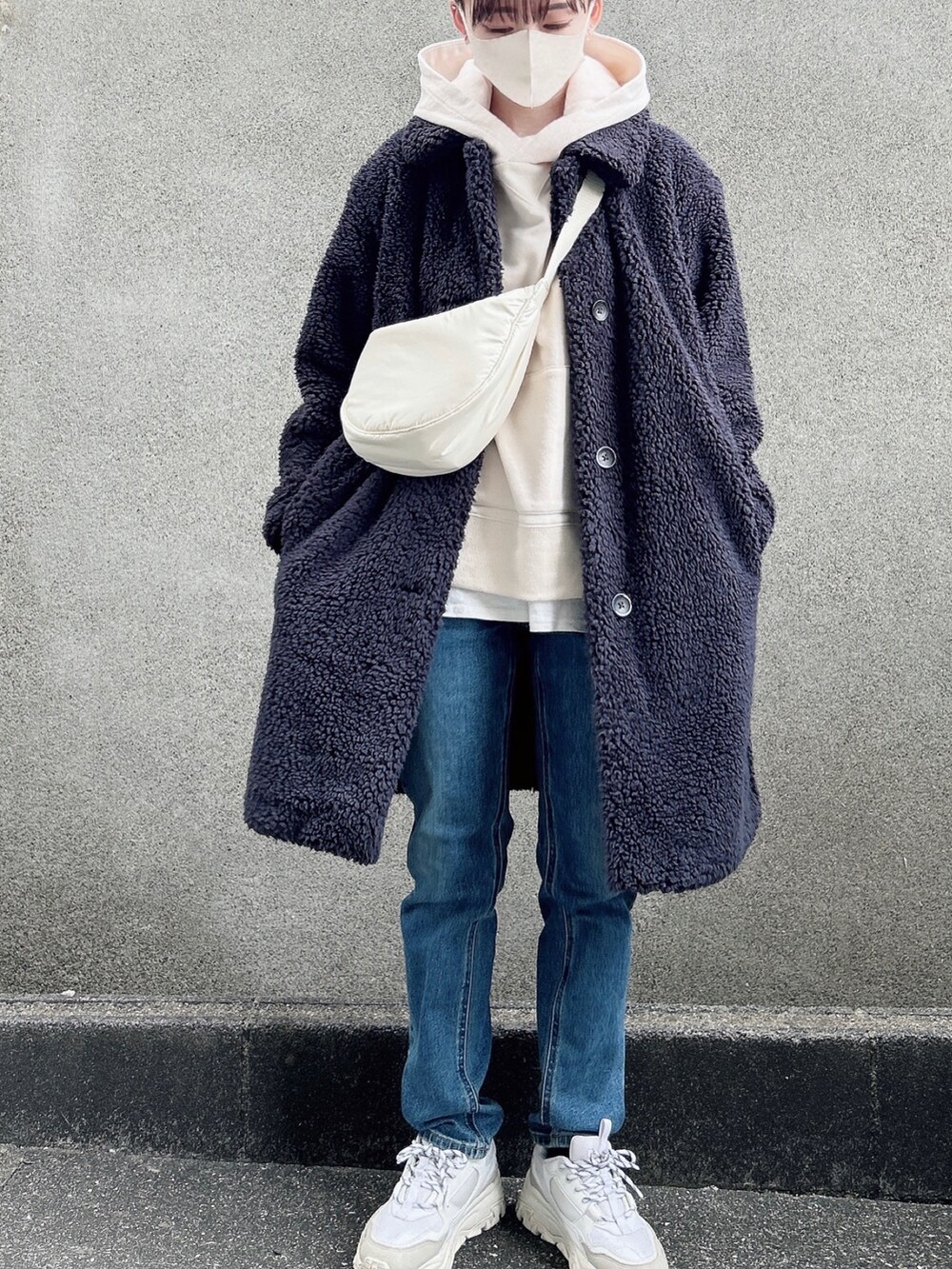 グレー系のステンカラーコート、ホワイト系のTシャツ/カットソー、ホワイト系のパーカーを着用したレディースの冬コーディネートの2枚目の写真