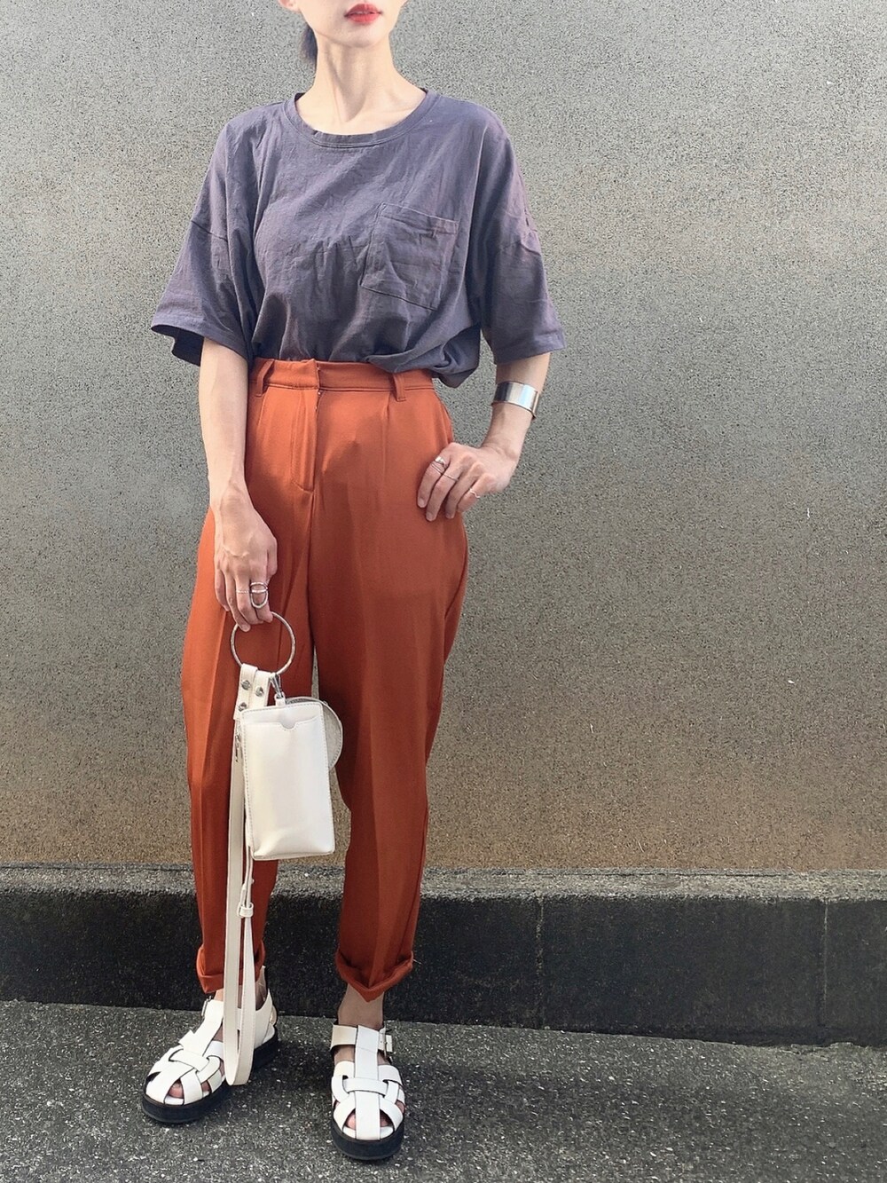 グレー系のTシャツ/カットソー、ホワイト系のショルダーバッグ、オレンジ系のスラックスを着用したレディースの夏コーディネートの3枚目の写真