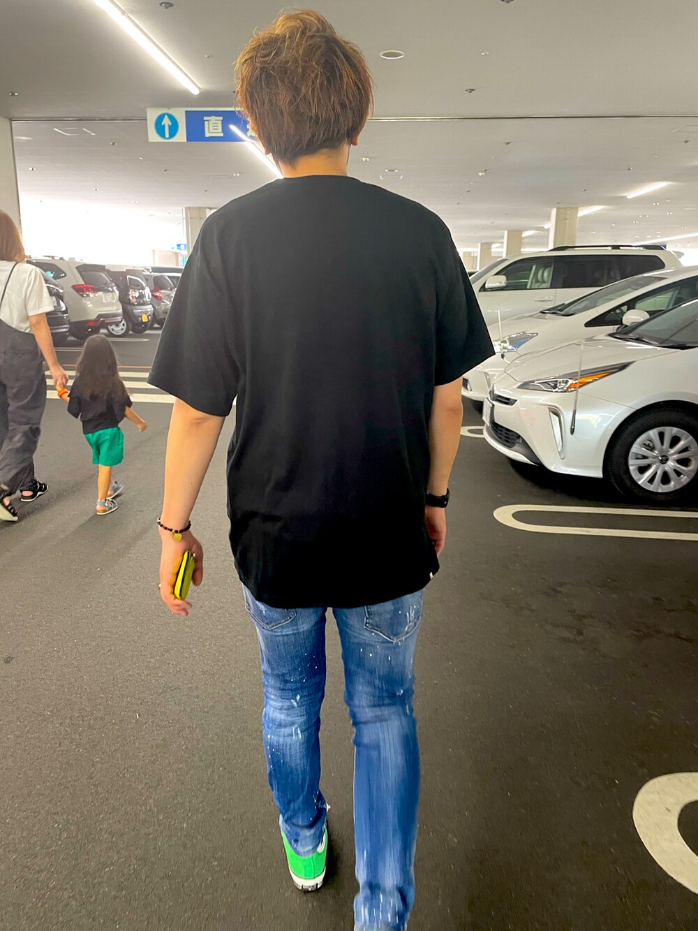 ブラック系のTシャツ/カットソー、ブルー系のデニムパンツ、グリーン系のスニーカーを着用したメンズの夏コーディネートの2枚目の写真