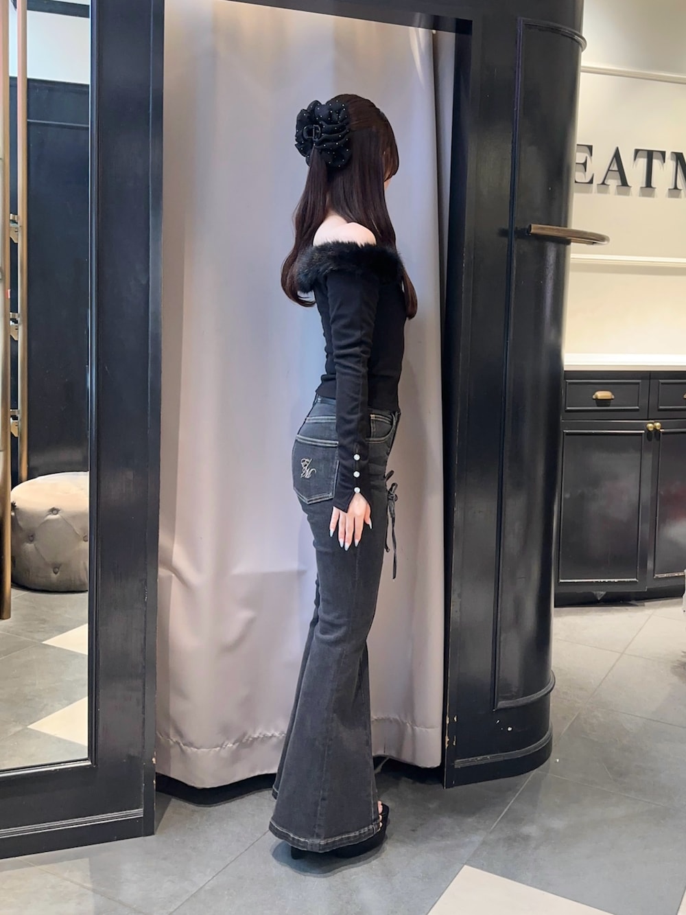 ブラック系のTシャツ/カットソー、ホワイト系のハンドバッグ、ブラック系のデニムパンツを着用したレディースの秋コーディネートの3枚目の写真
