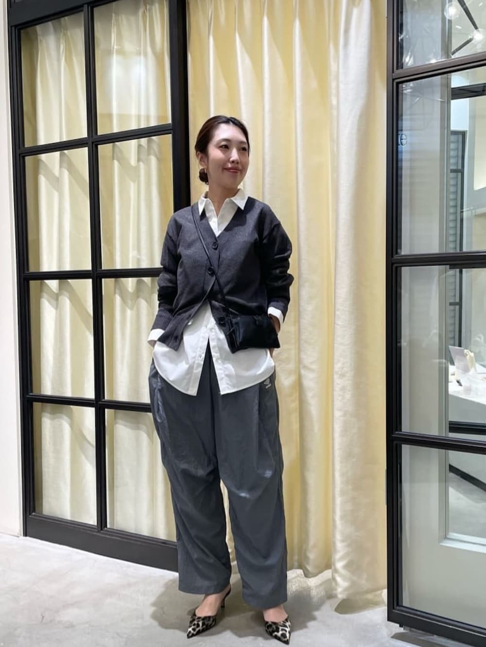 グレー系のカーディガン/ボレロ、グレー系のその他パンツ、イエロー系のパンプスを着用したレディースの冬コーディネートの3枚目の写真