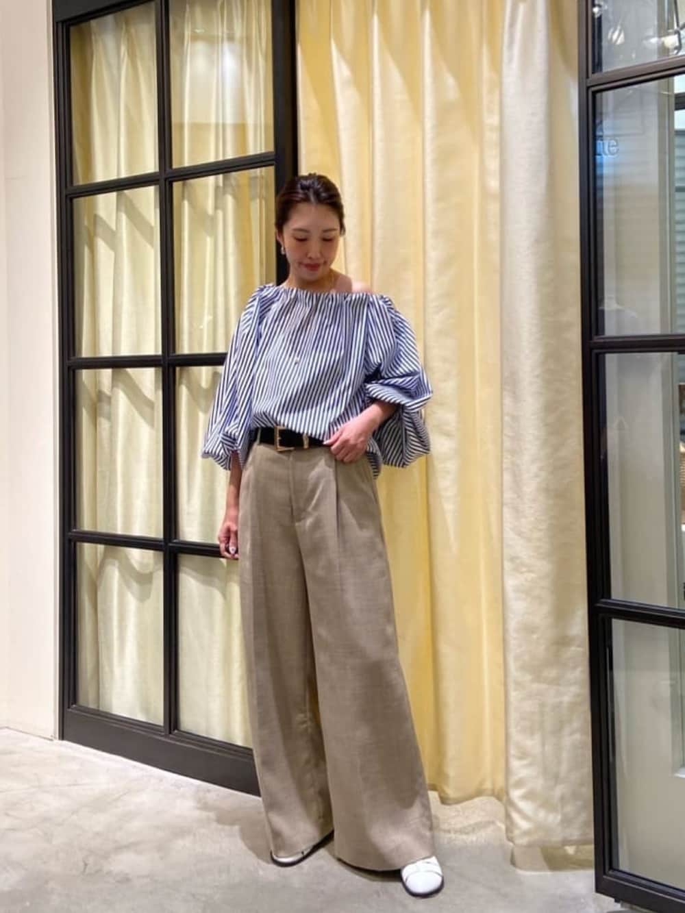 ブルー系のシャツ/ブラウス、ベージュ系のパンツ、ホワイト系のサンダルを着用したレディースの春コーディネートの4枚目の写真