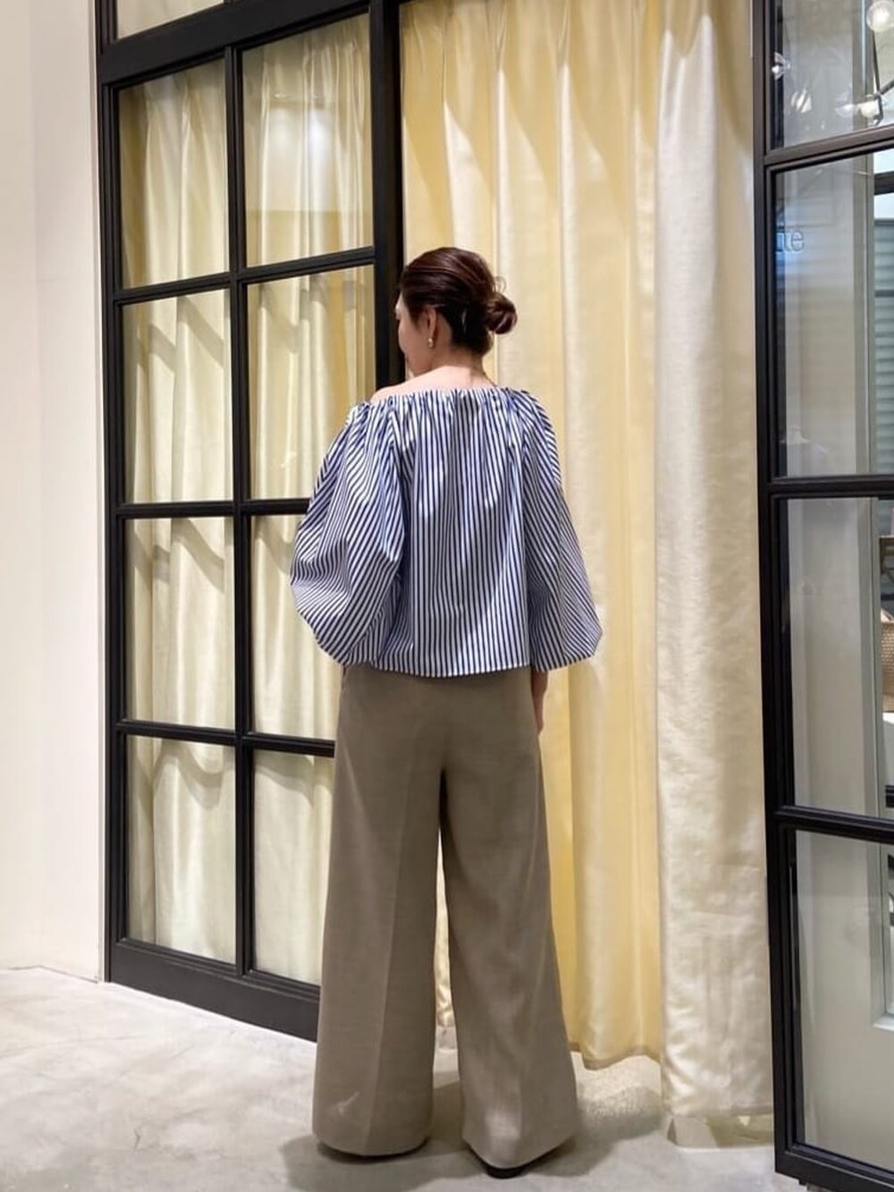 ブルー系のシャツ/ブラウス、ベージュ系のパンツ、ホワイト系のサンダルを着用したレディースの春コーディネートの3枚目の写真