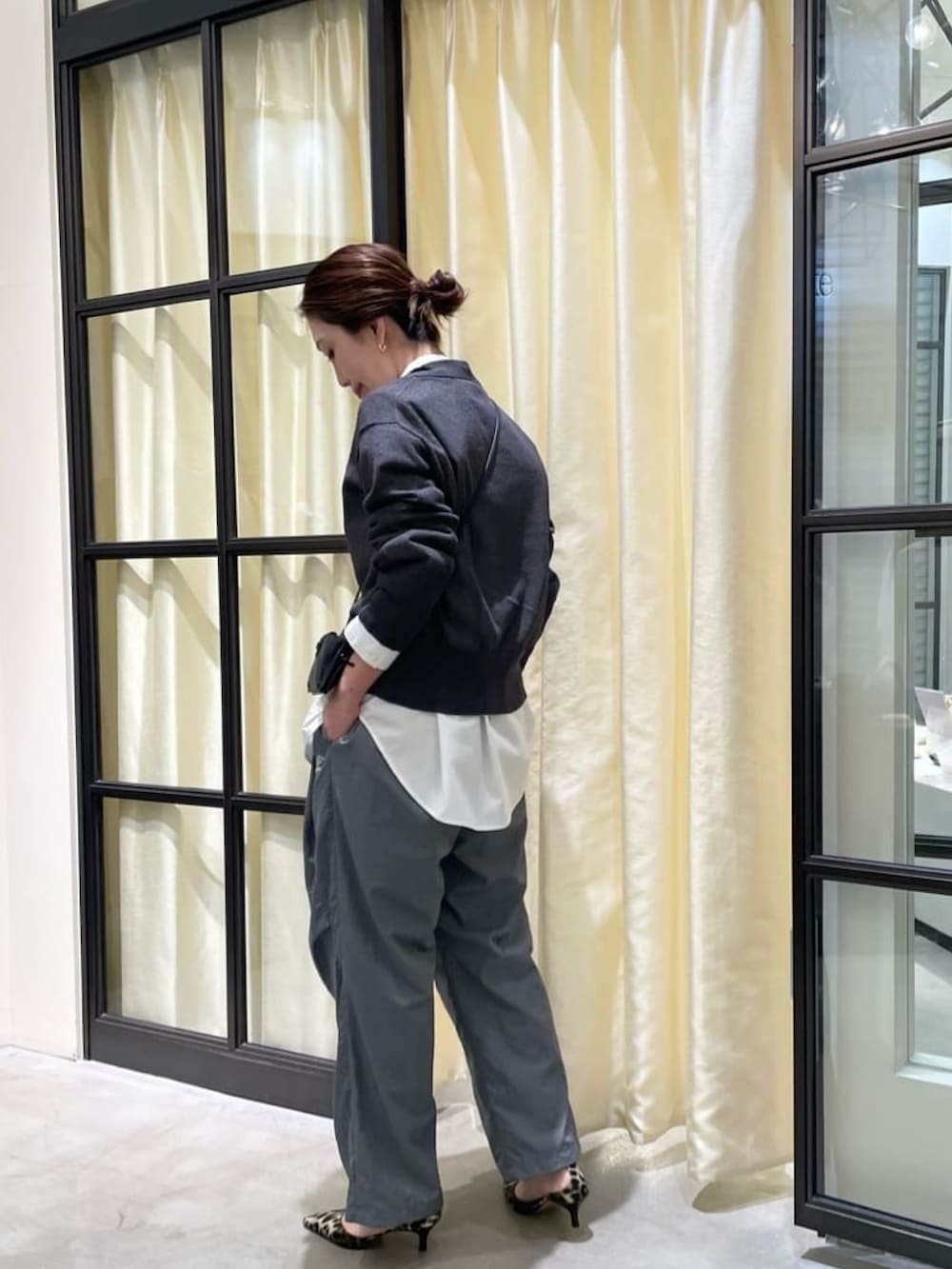 グレー系のカーディガン/ボレロ、グレー系のその他パンツ、イエロー系のパンプスを着用したレディースの冬コーディネートの2枚目の写真