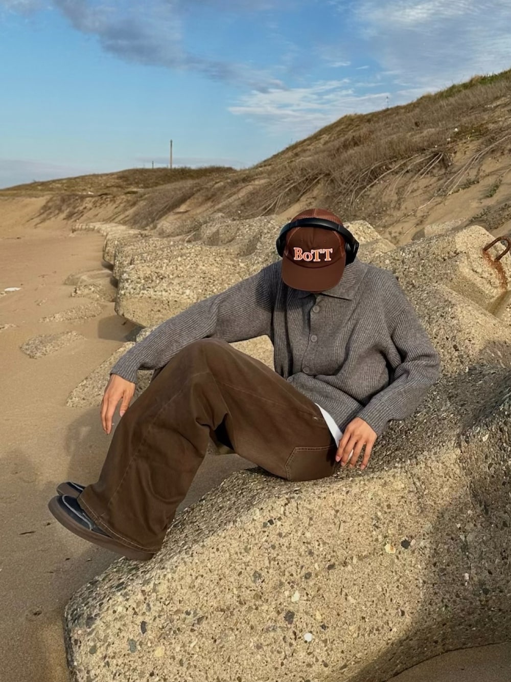 ブラック系のスニーカー、ブラウン系のキャップを着用したメンズの冬コーディネートの3枚目の写真