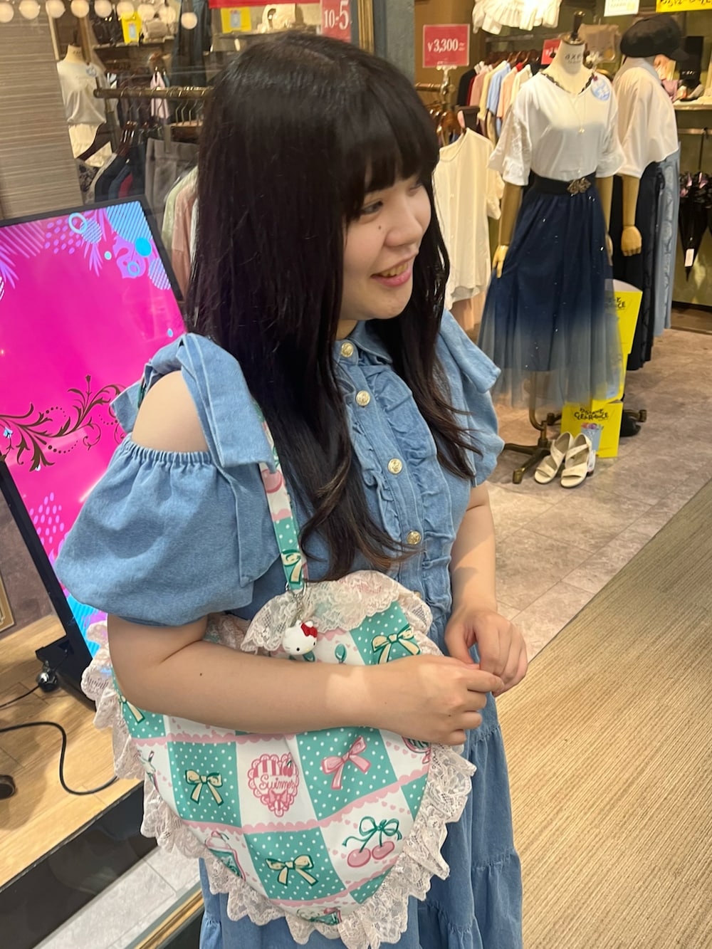 ブルー系のワンピース、グリーン系のトートバッグ、ホワイト系のスニーカーを着用したレディースの夏コーディネートの2枚目の写真