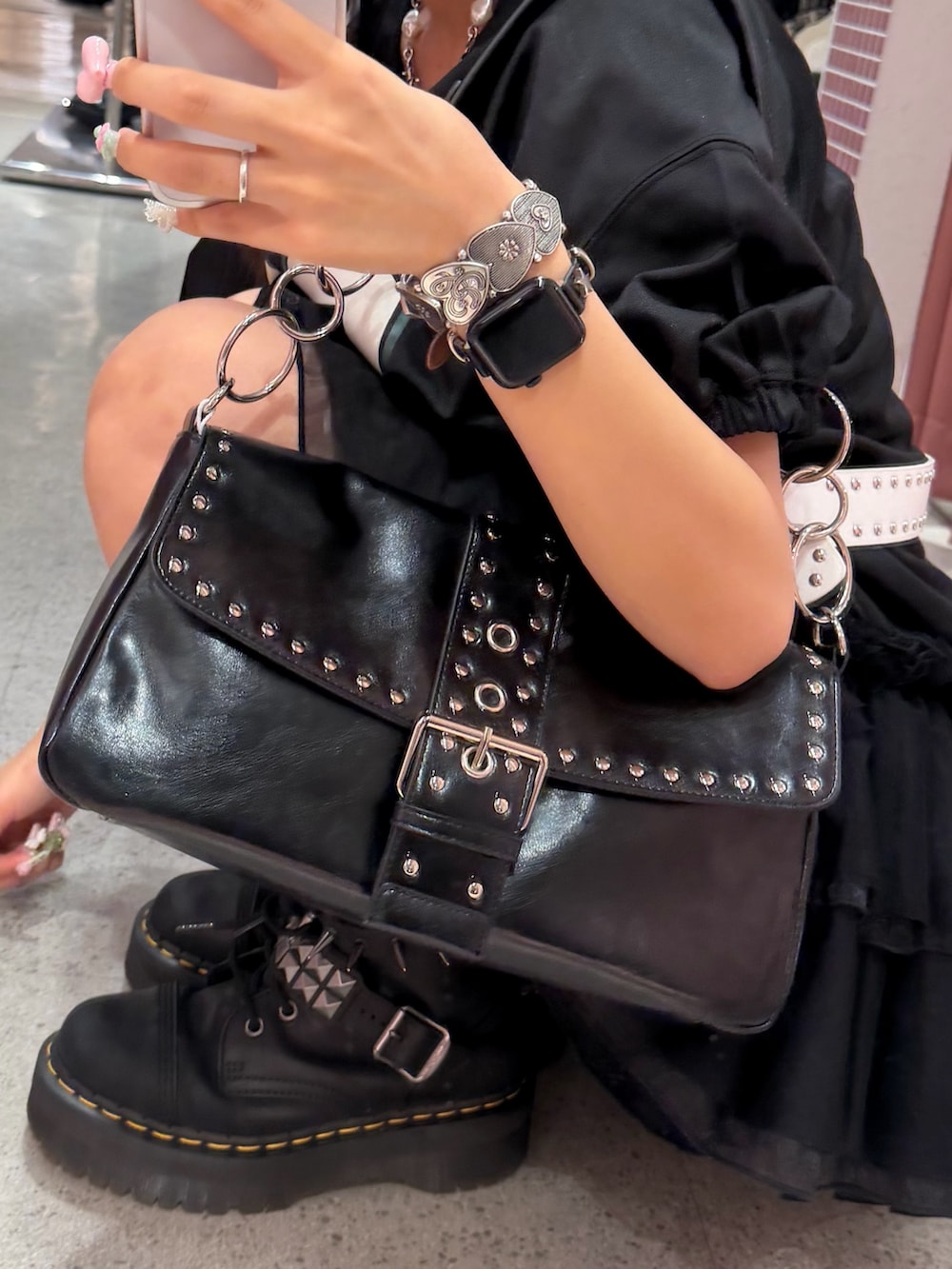 ブラック系のワンピース、ブラック系のハンドバッグ、ブラック系のブーツを着用したレディースの春コーディネートの4枚目の写真