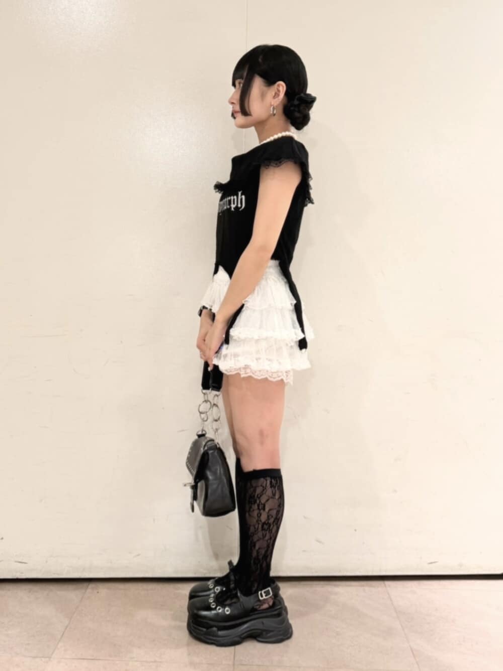 ブラック系のハンドバッグ、ブラック系のパンプス、ブラック系のTシャツ/カットソーを着用したレディースの夏コーディネートの3枚目の写真