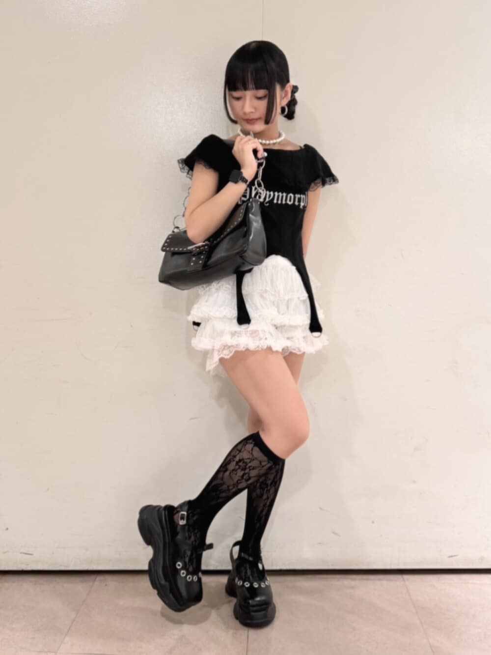 ブラック系のハンドバッグ、ブラック系のパンプス、ブラック系のTシャツ/カットソーを着用したレディースの夏コーディネートの2枚目の写真