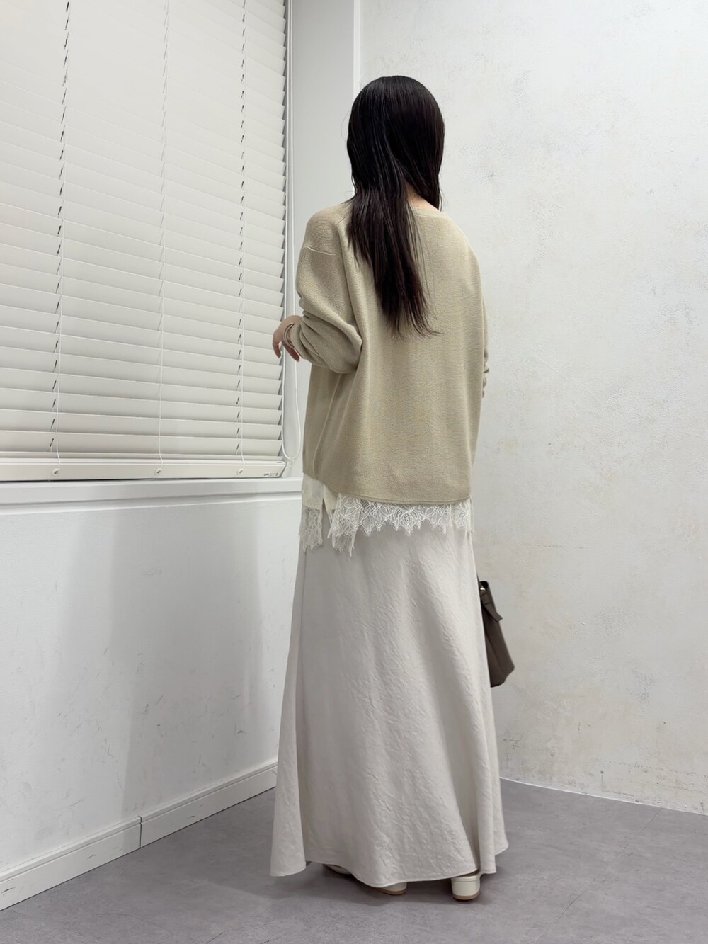 ベージュ系のニット/セーター、ホワイト系のシャツ/ブラウス、ホワイト系のスカートを着用したレディースの春コーディネートの3枚目の写真