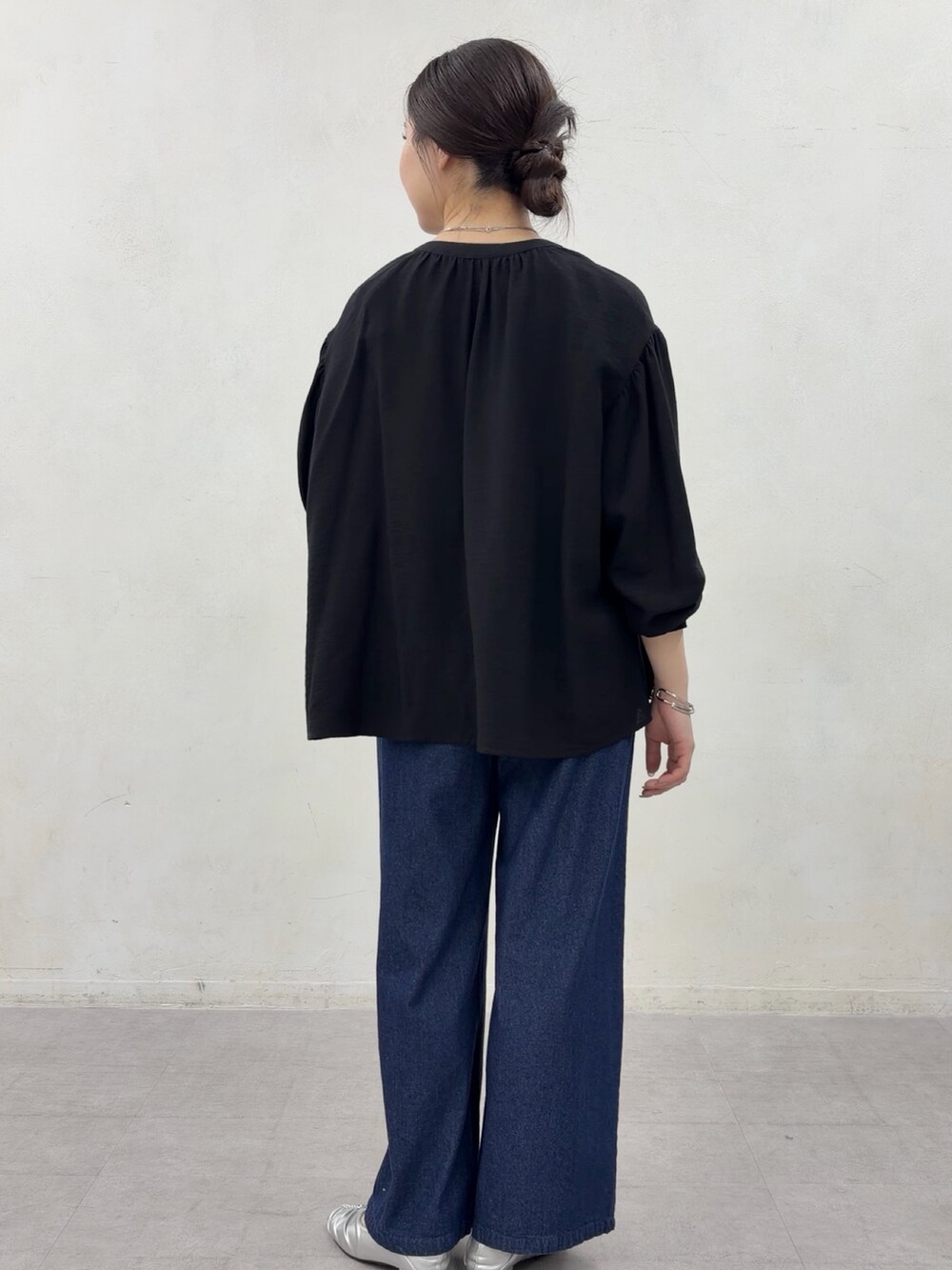 ブラック系のシャツ/ブラウス、ブルー系のデニムパンツ、シルバー系のその他シューズを着用したレディースの春コーディネートの2枚目の写真