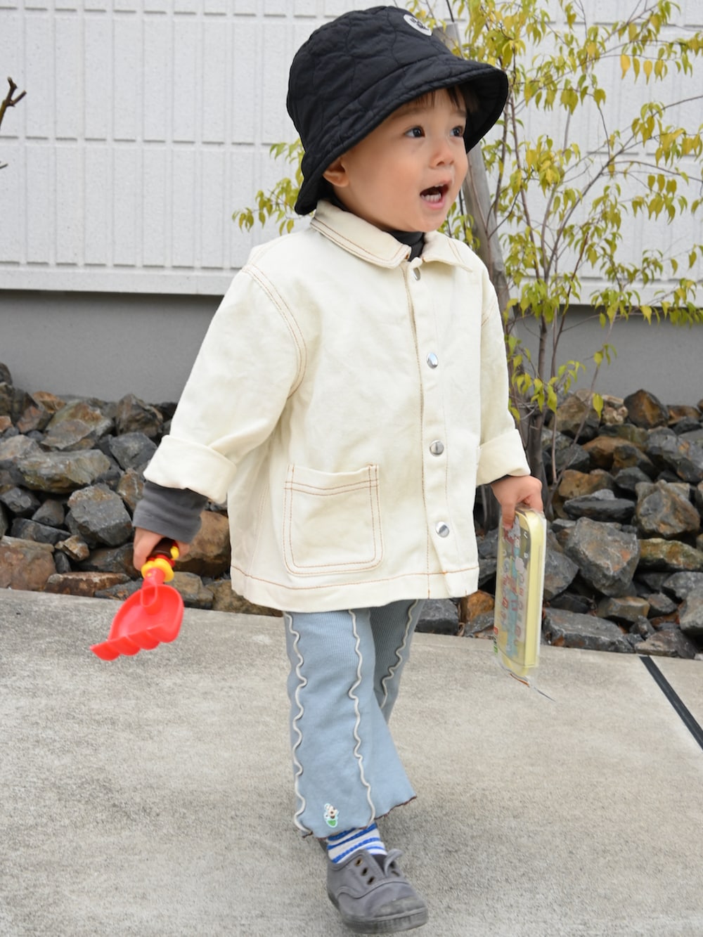 ホワイト系のデニムジャケット、ブルー系のパンツ、ブラック系のスニーカーを着用したキッズの春コーディネートの2枚目の写真