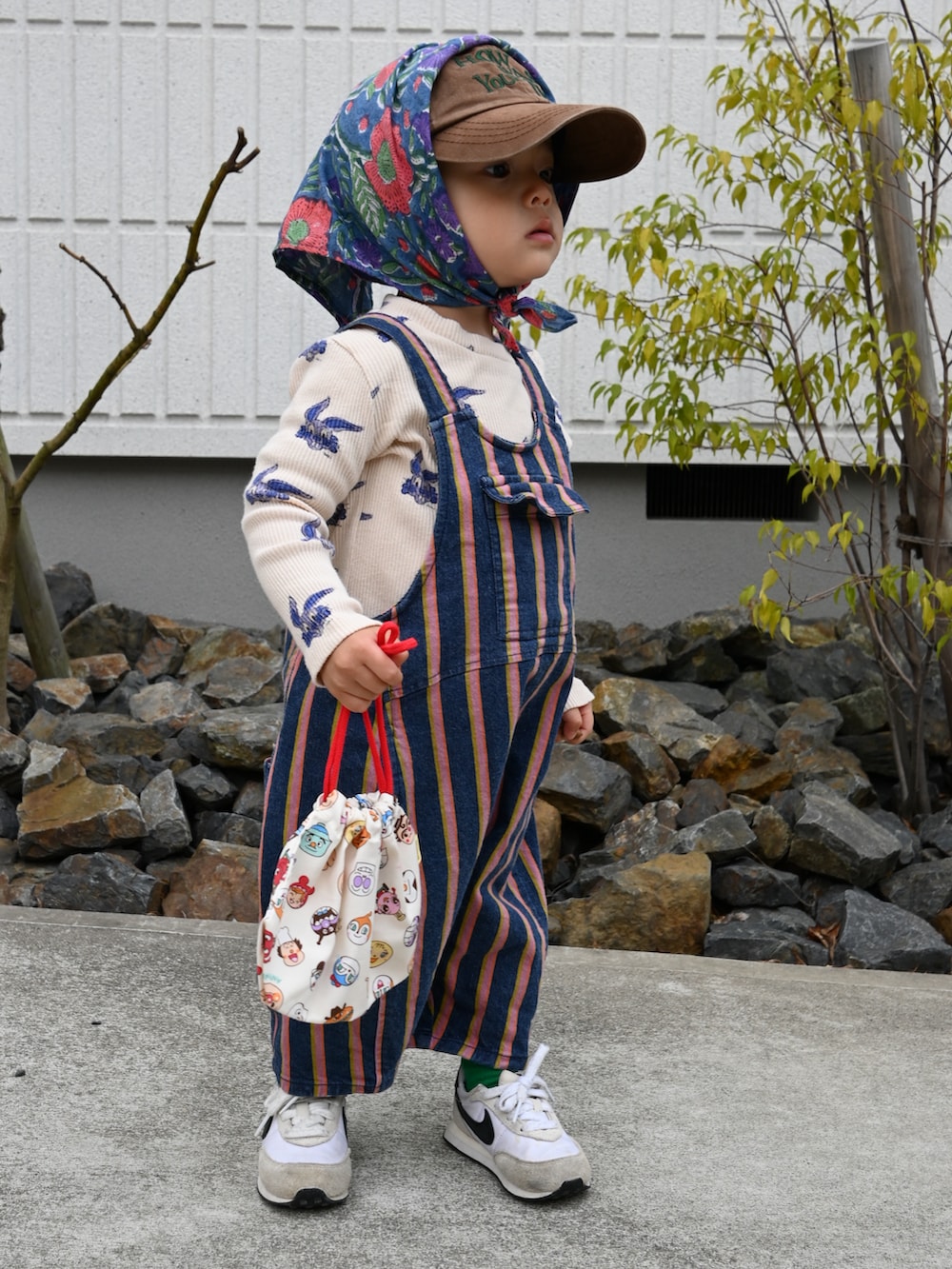 ベージュ系のTシャツ/カットソー、ブルー系のオールインワン・サロペット、ホワイト系のスニーカーを着用したキッズの冬コーディネートの2枚目の写真